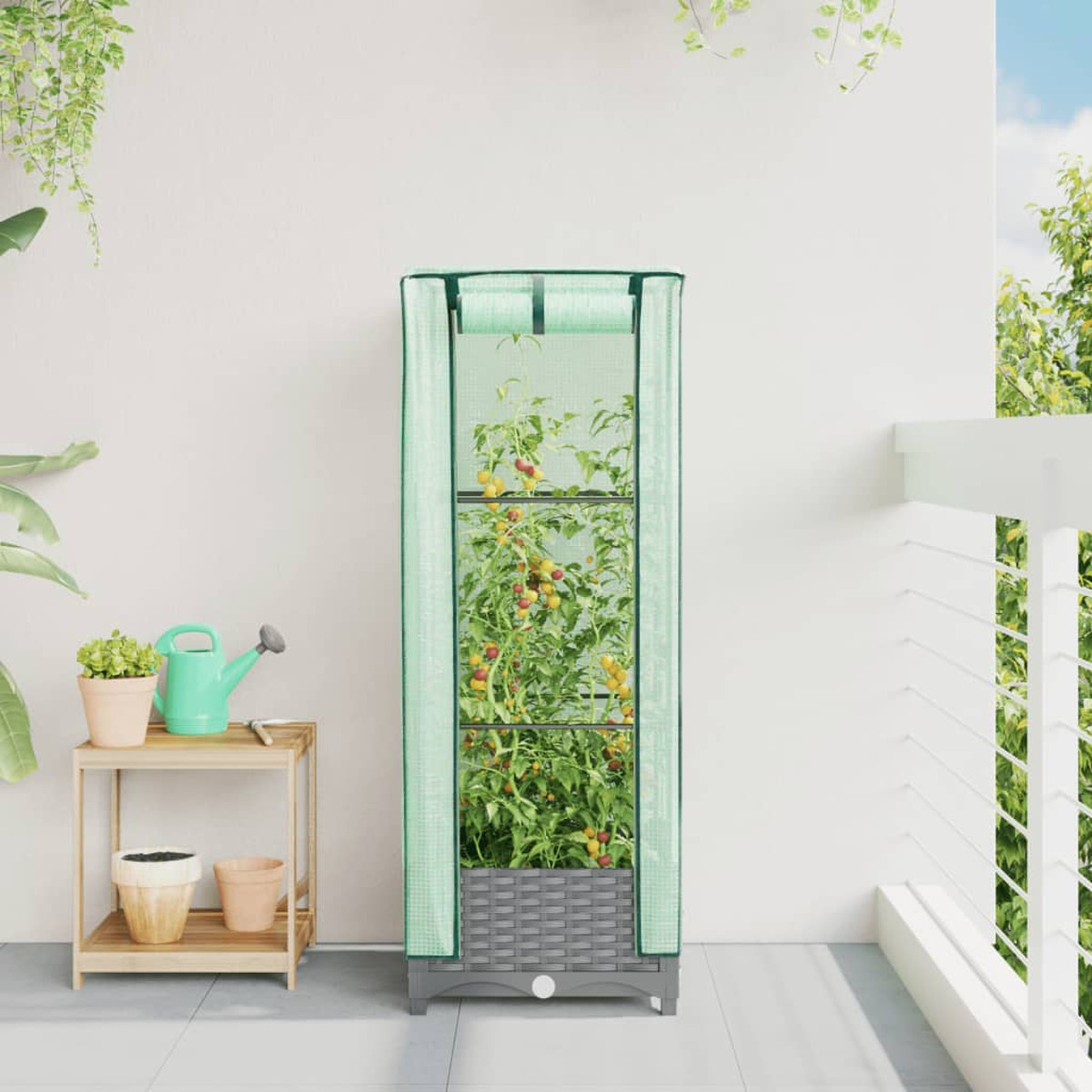 Una piccola serra con piante su un balcone.