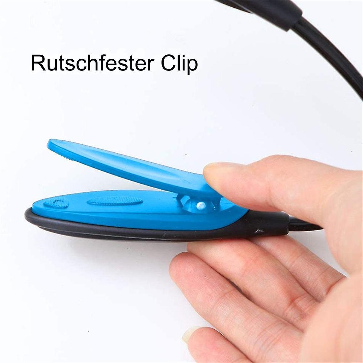Hand hält einen blauen Clip mit der Aufschrift 'Rutschfester Clip'. Weißer Hintergrund.