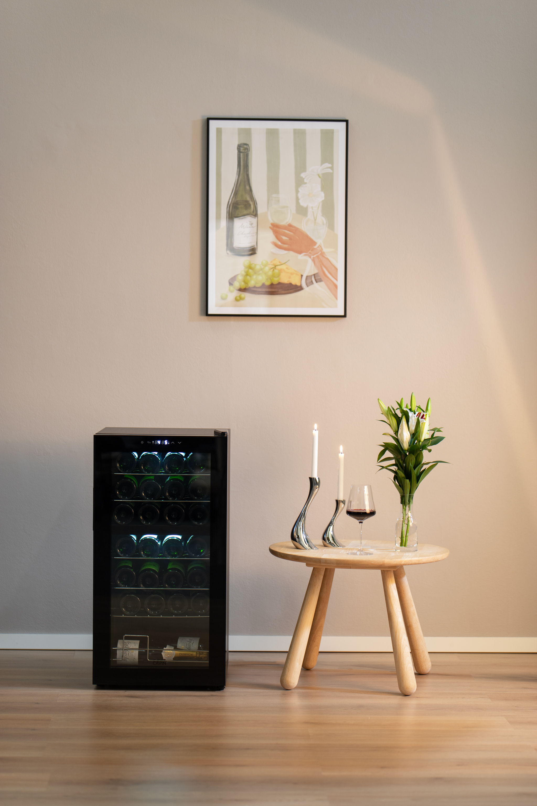 Weinkeller mit Flaschen, Tisch mit Wein und Blumen und ein Gemälde an der Wand.
