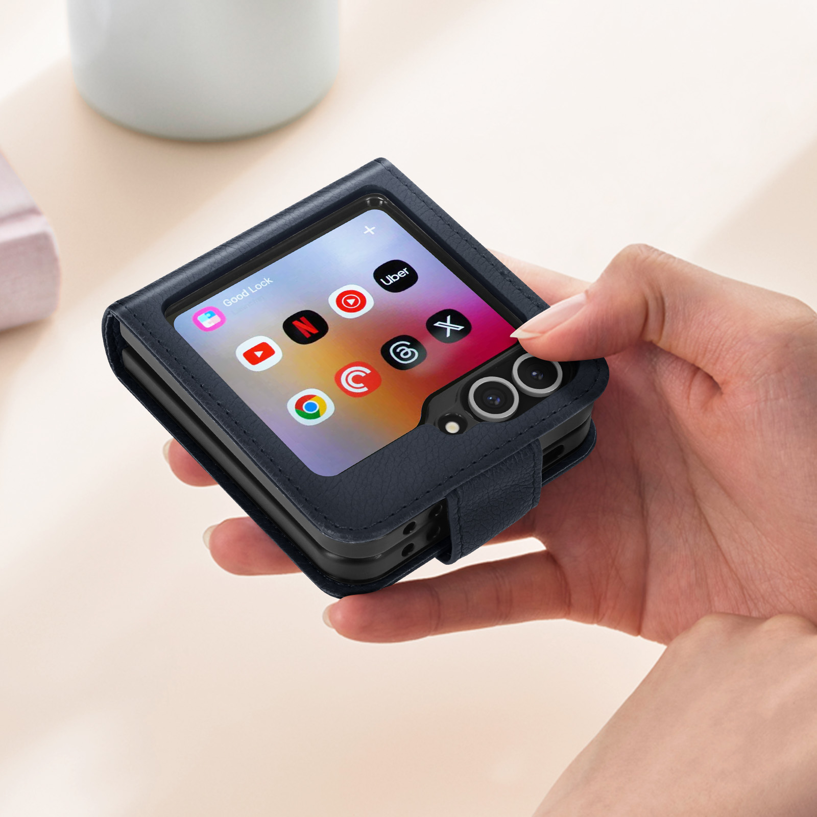 Persona che tiene una custodia per telefono blu scuro con icone delle app.