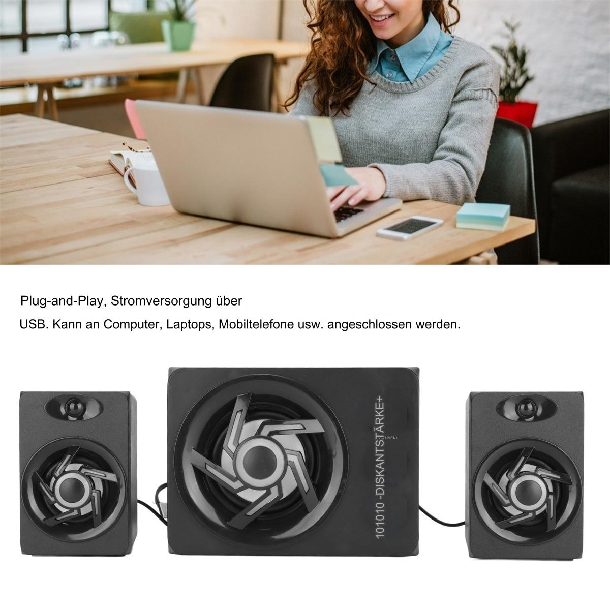 Eine Frau benutzt einen Laptop an einem Holztisch. Lautsprecher sind im Vordergrund.
