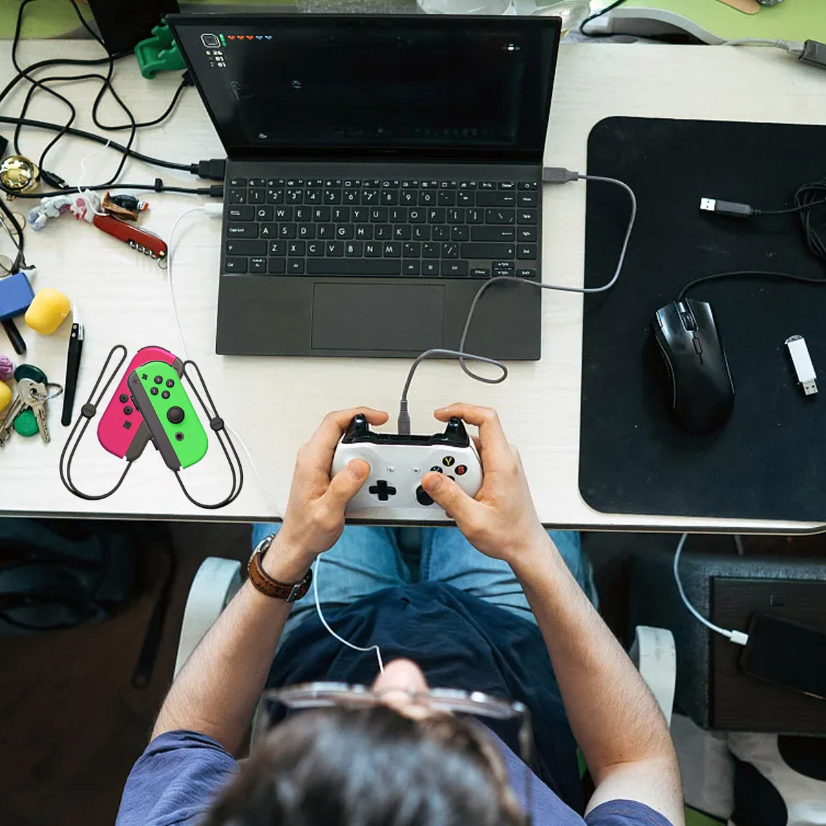 Eine Person spielt ein Spiel auf einem Laptop. Controller in den Händen, eine Maus und anderes Zubehör.