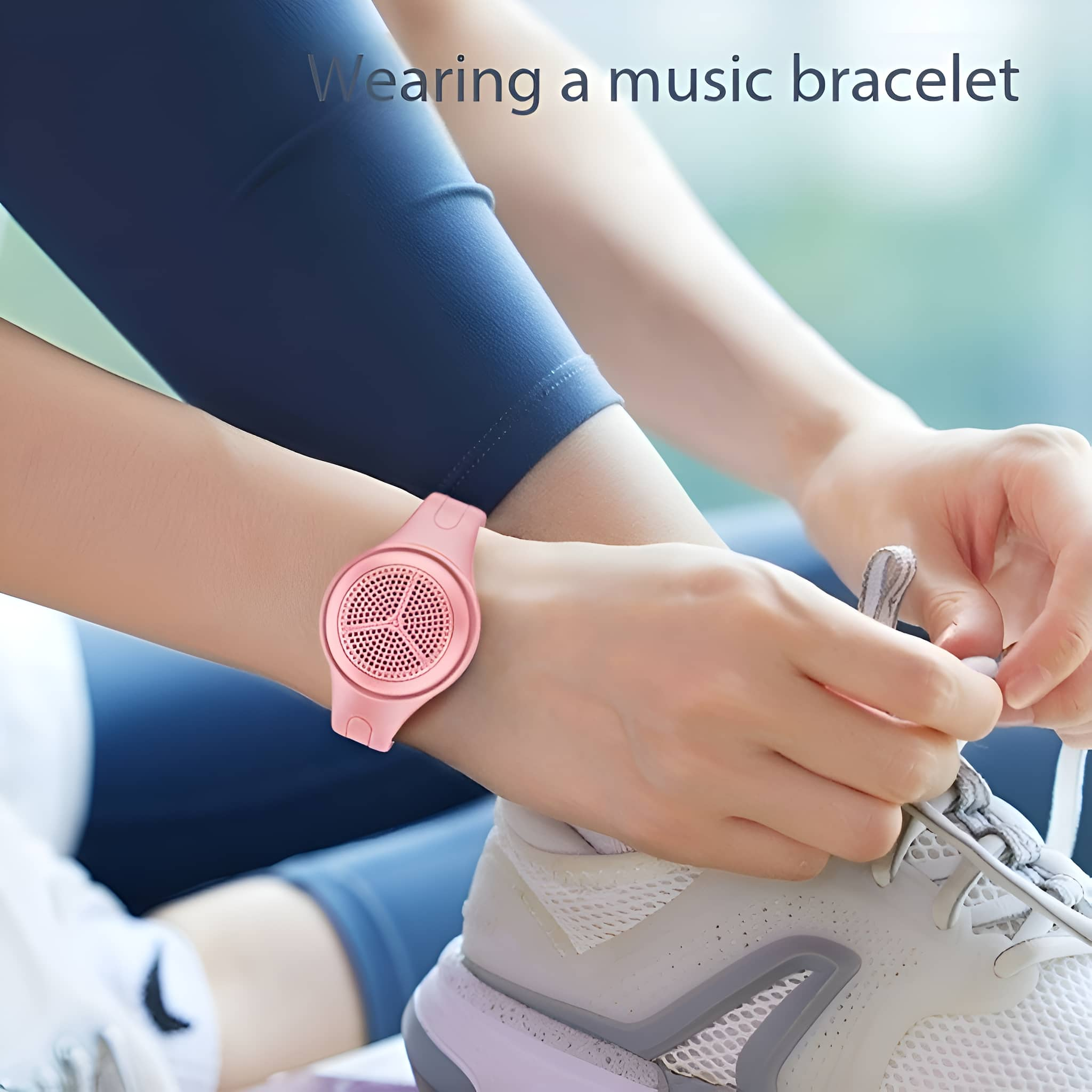 Das Handgelenk einer Person mit einem rosa Musikarmband.