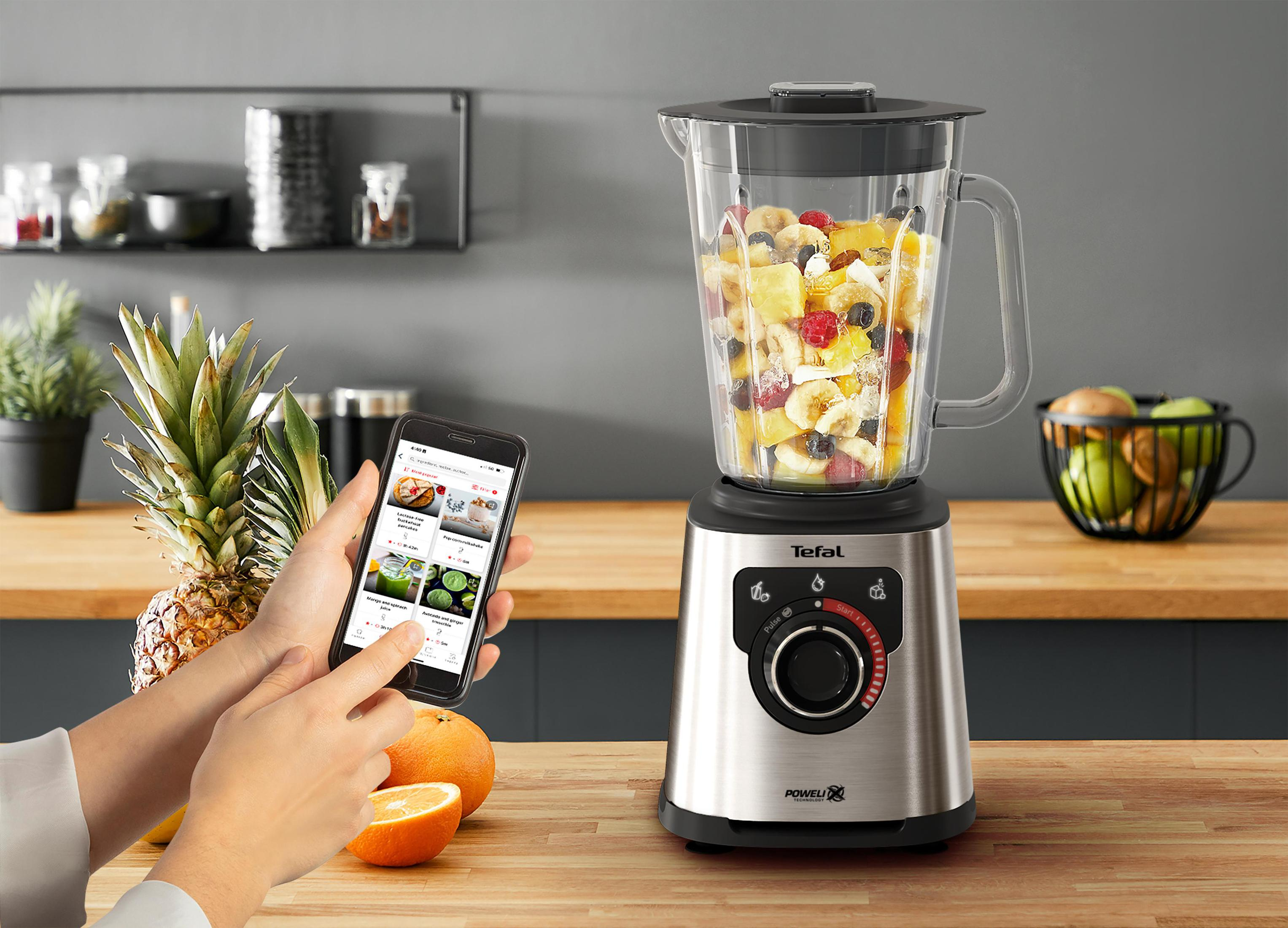 Un frullatore con frutta e un telefono con ricette.