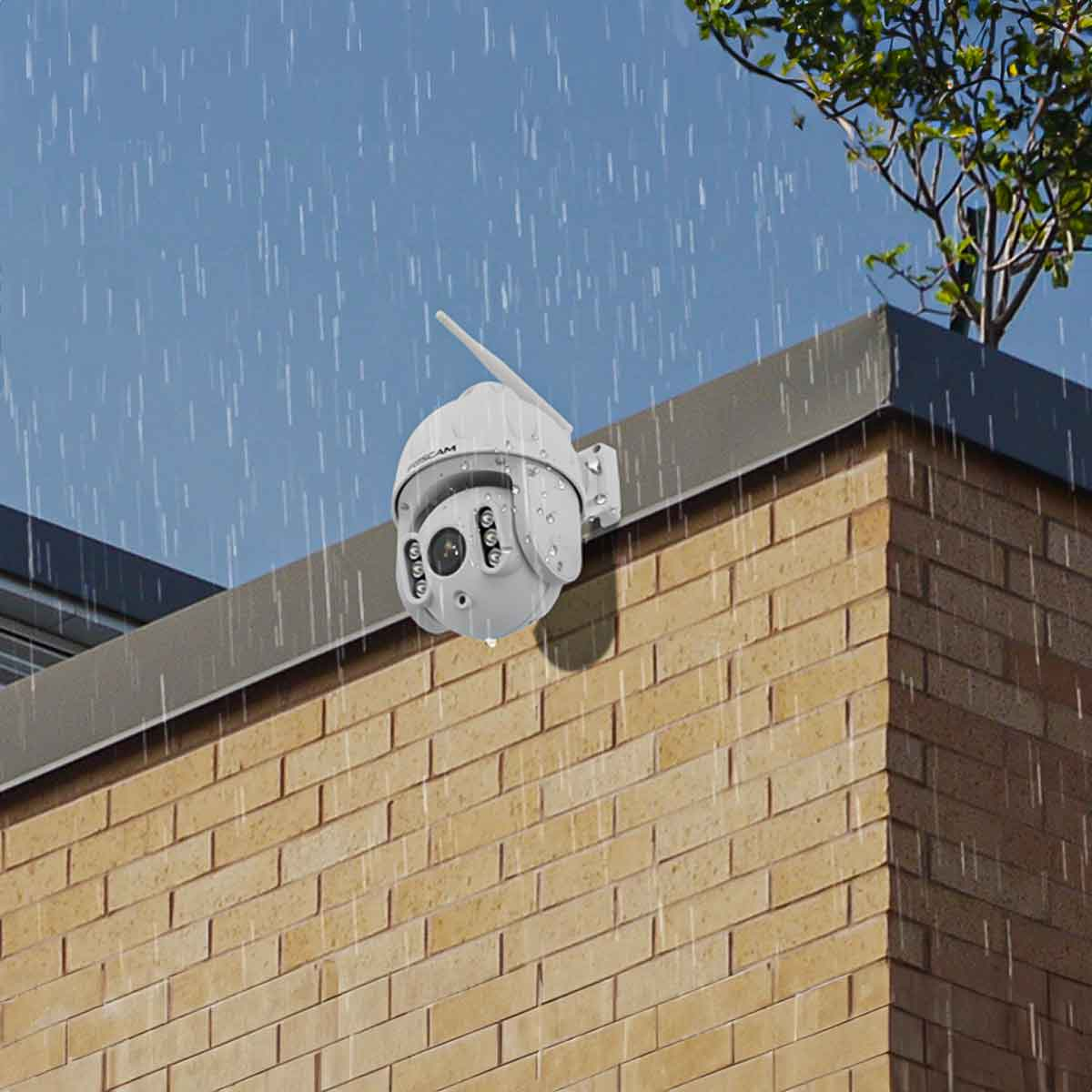 Eine weiße Überwachungskamera an einer Ziegelmauer montiert. Regen fällt, was auf eine Nutzung im Freien hindeutet.