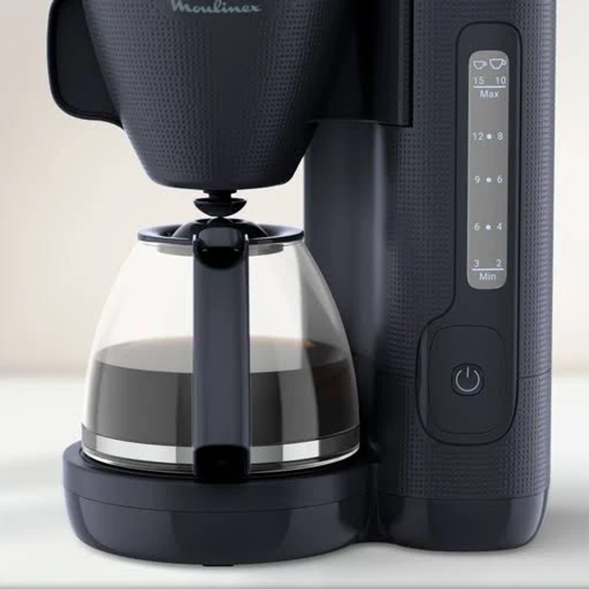 A black Moulinex coffee maker with a glass carafe filled with coffee. There is a water level indicator.