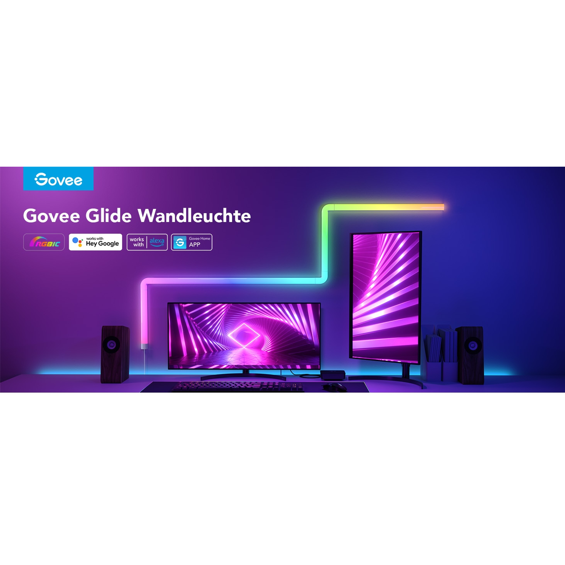 Govee Glide Wandleuchten auf einem Schreibtisch mit Monitoren und Lautsprechern. Lila und grüne Lichter.