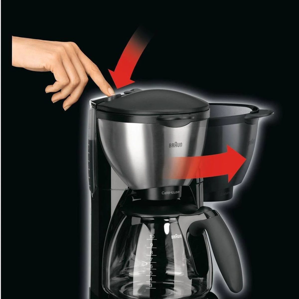 Hand drukt op een knop van een Braun koffiezetapparaat, zilveren kan en zwarte delen.