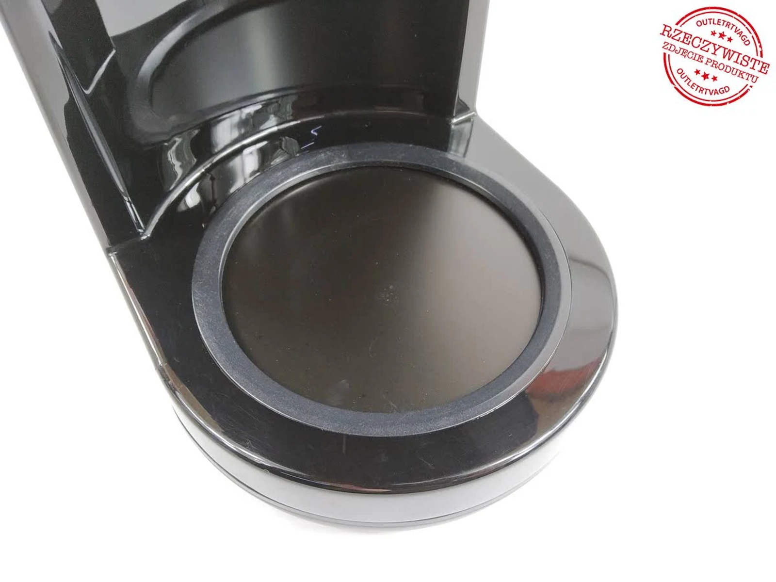 Zbliżenie podstawy czarnego ekspresu do kawy. Widoczny okrągły obszar wewnątrz podstawy.