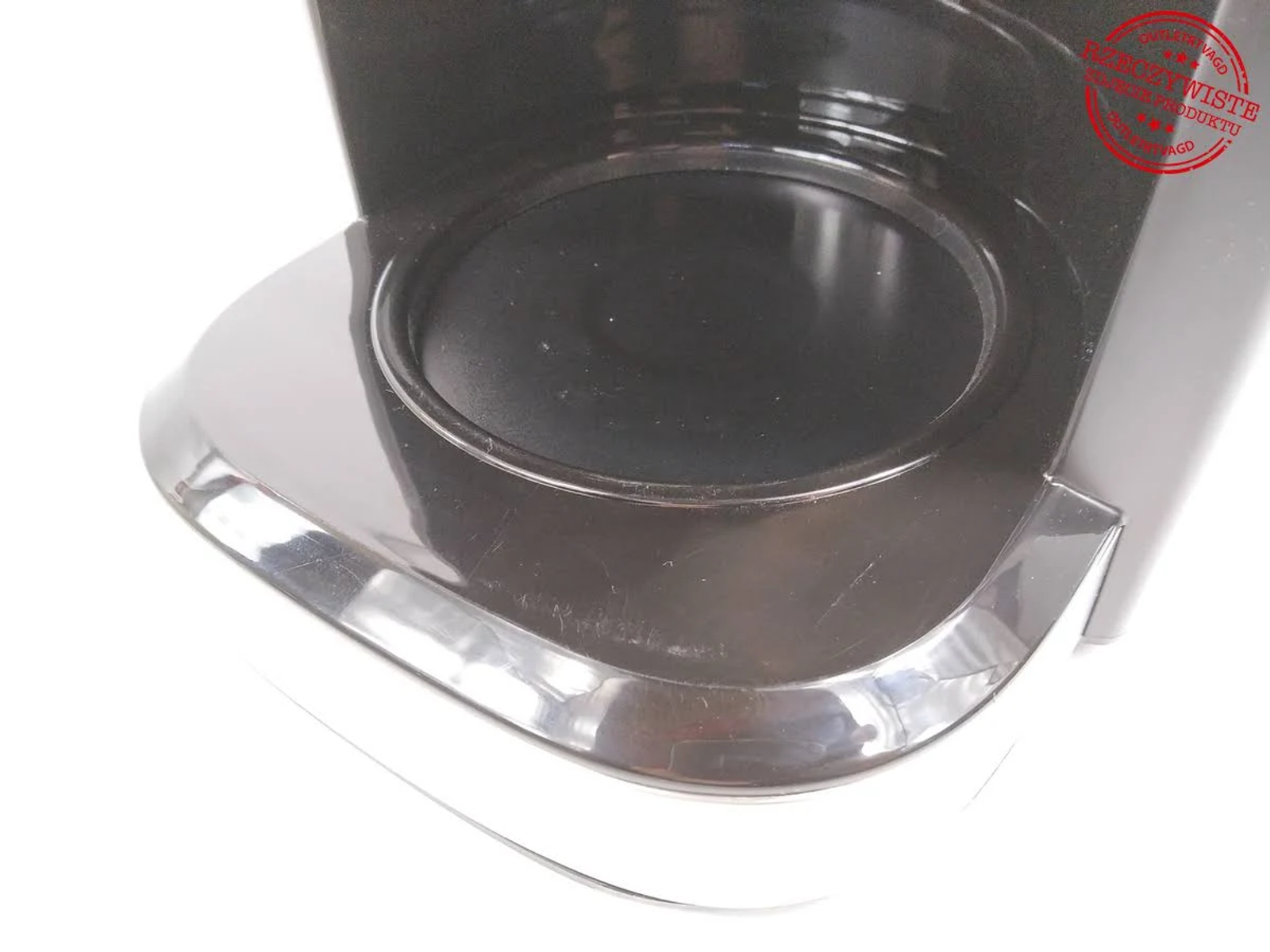 Zbliżenie wnętrza czarnego ekspresu do kawy, białe tło.