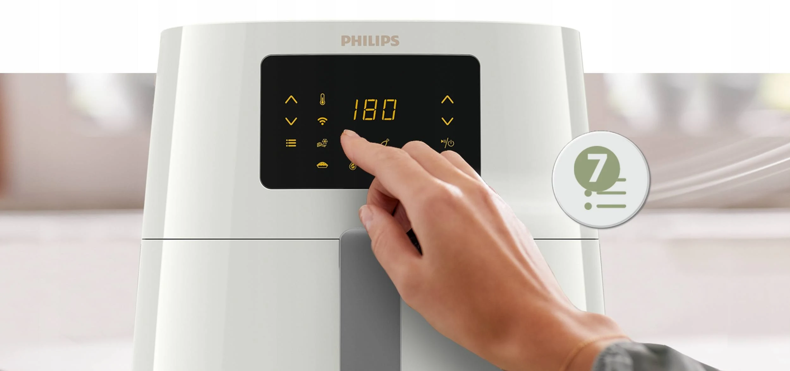 Zbliżenie na dłoń osoby dotykającą wyświetlacza białej frytownicy beztłuszczowej.