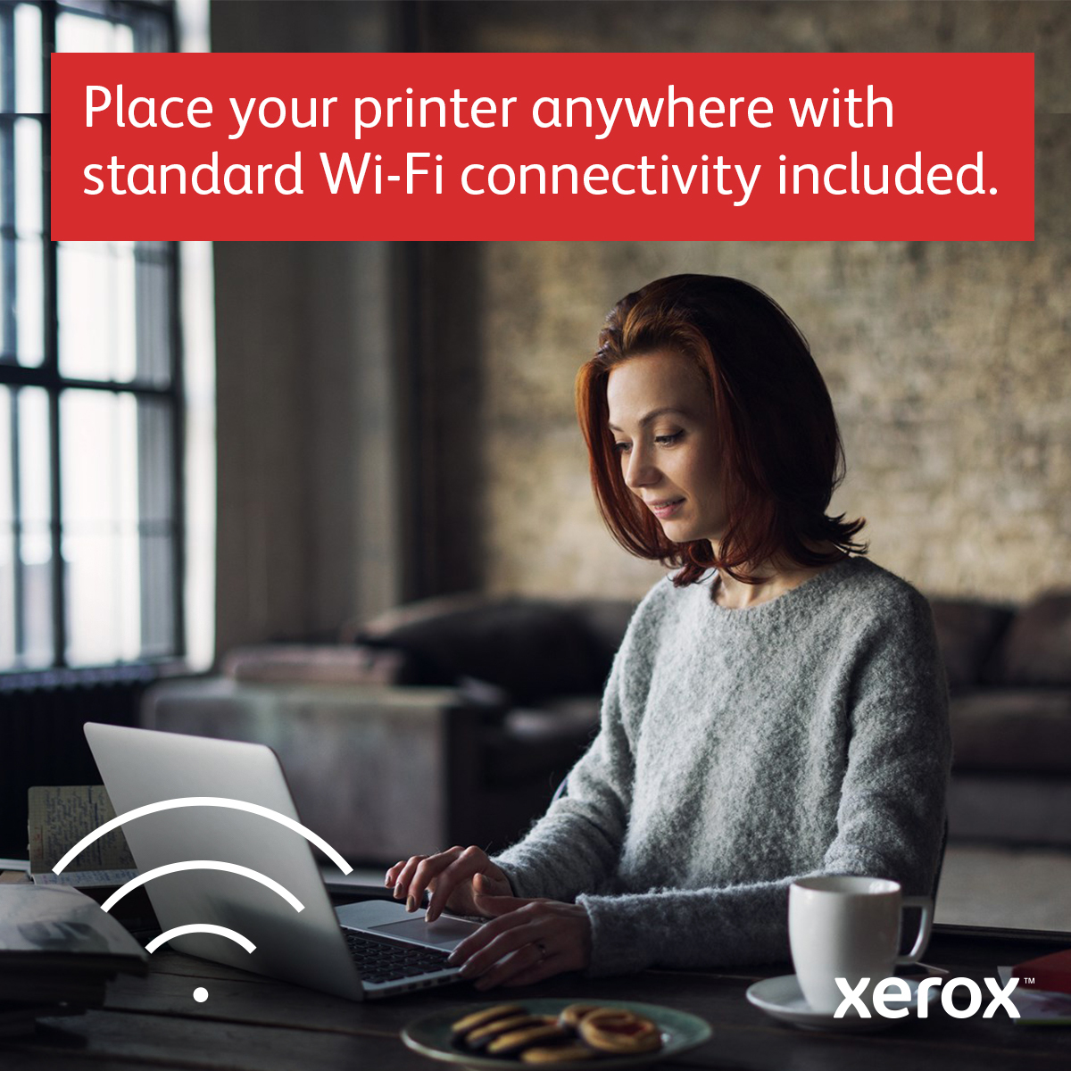 Kobieta korzystająca z laptopa z ikoną wifi, kawą i ciasteczkami na stole.