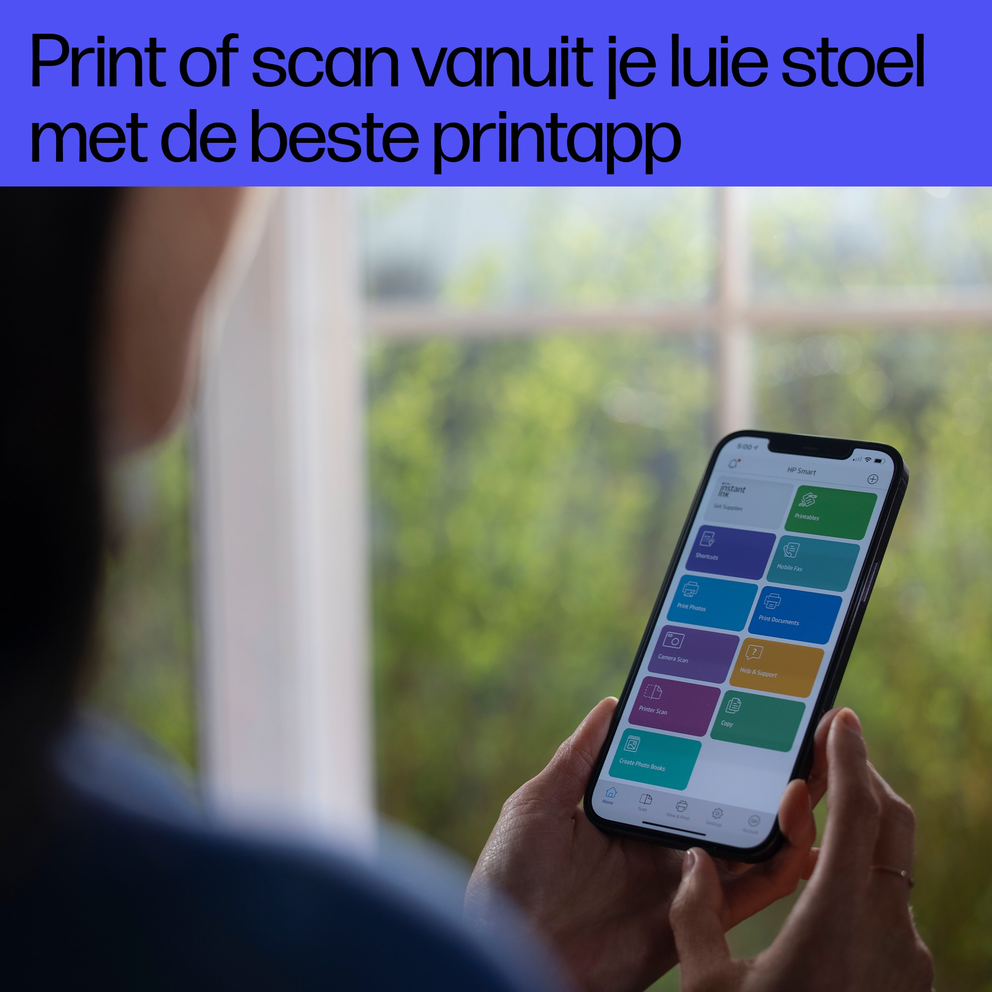 Osoba trzymająca telefon z aplikacją, w tle okno.