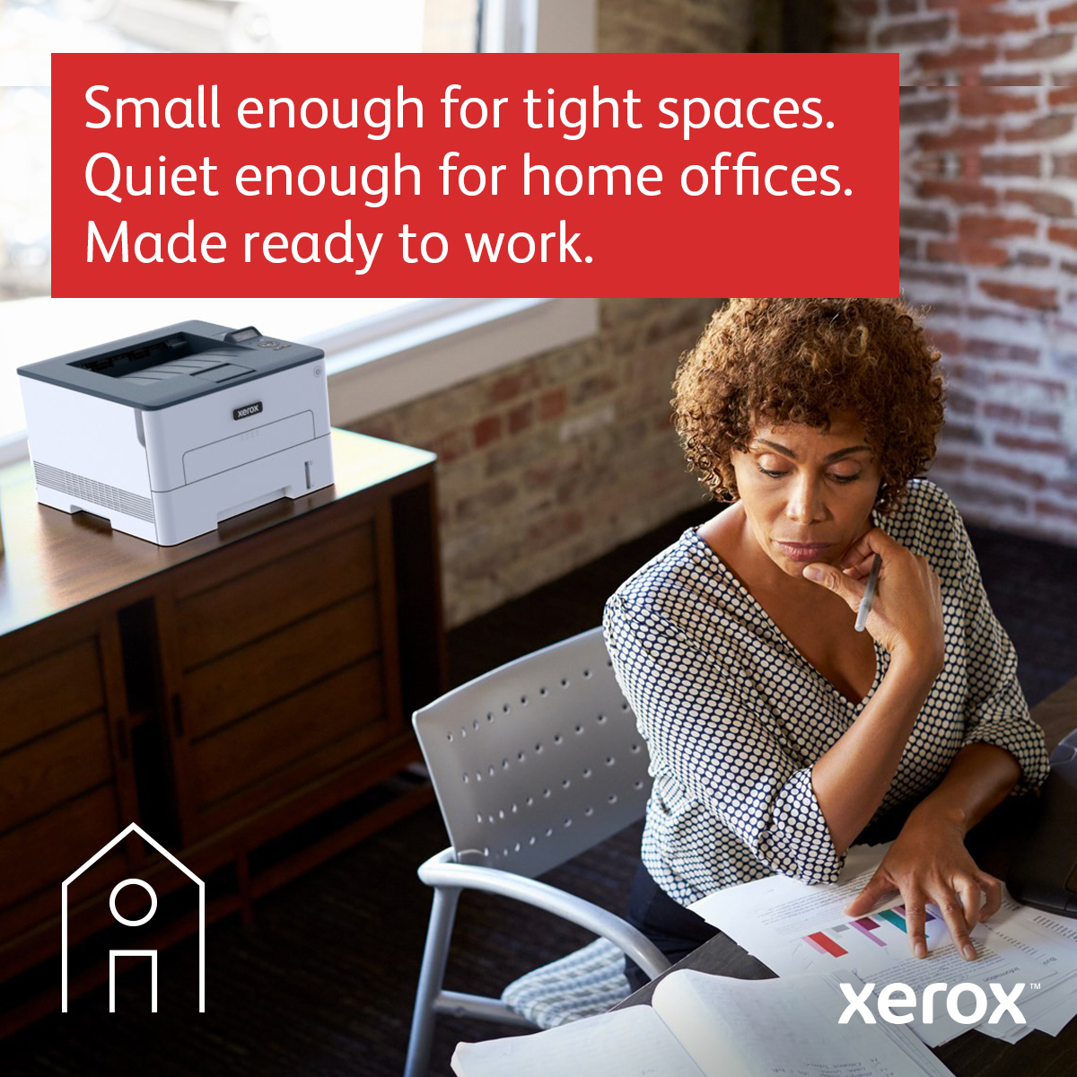 Kobieta przeglądająca dokumenty, drukarka na biurku z logo.