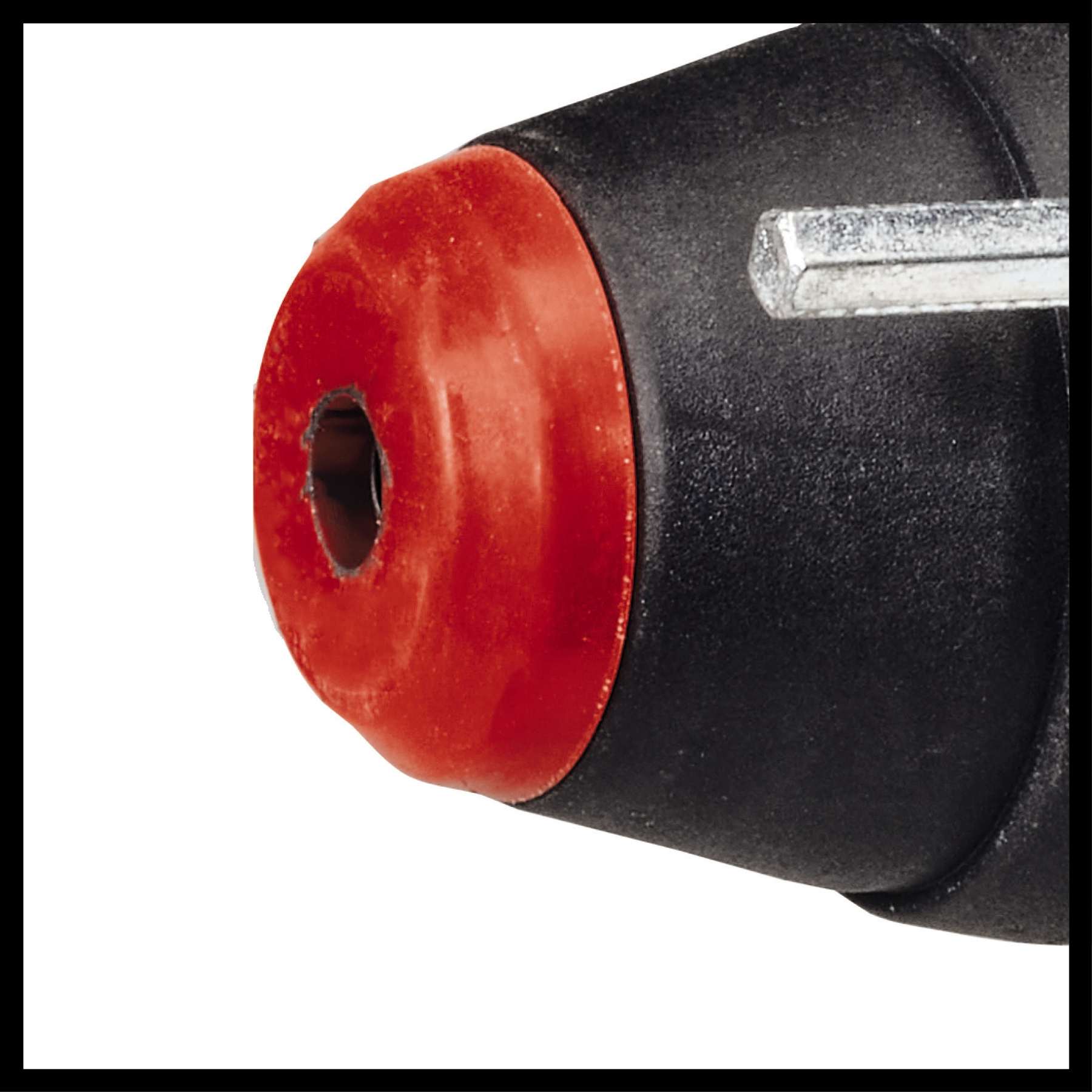 Zbliżenie czarnej i czerwonej dyszy pistoletu do klejenia. Obok klucz imbusowy.