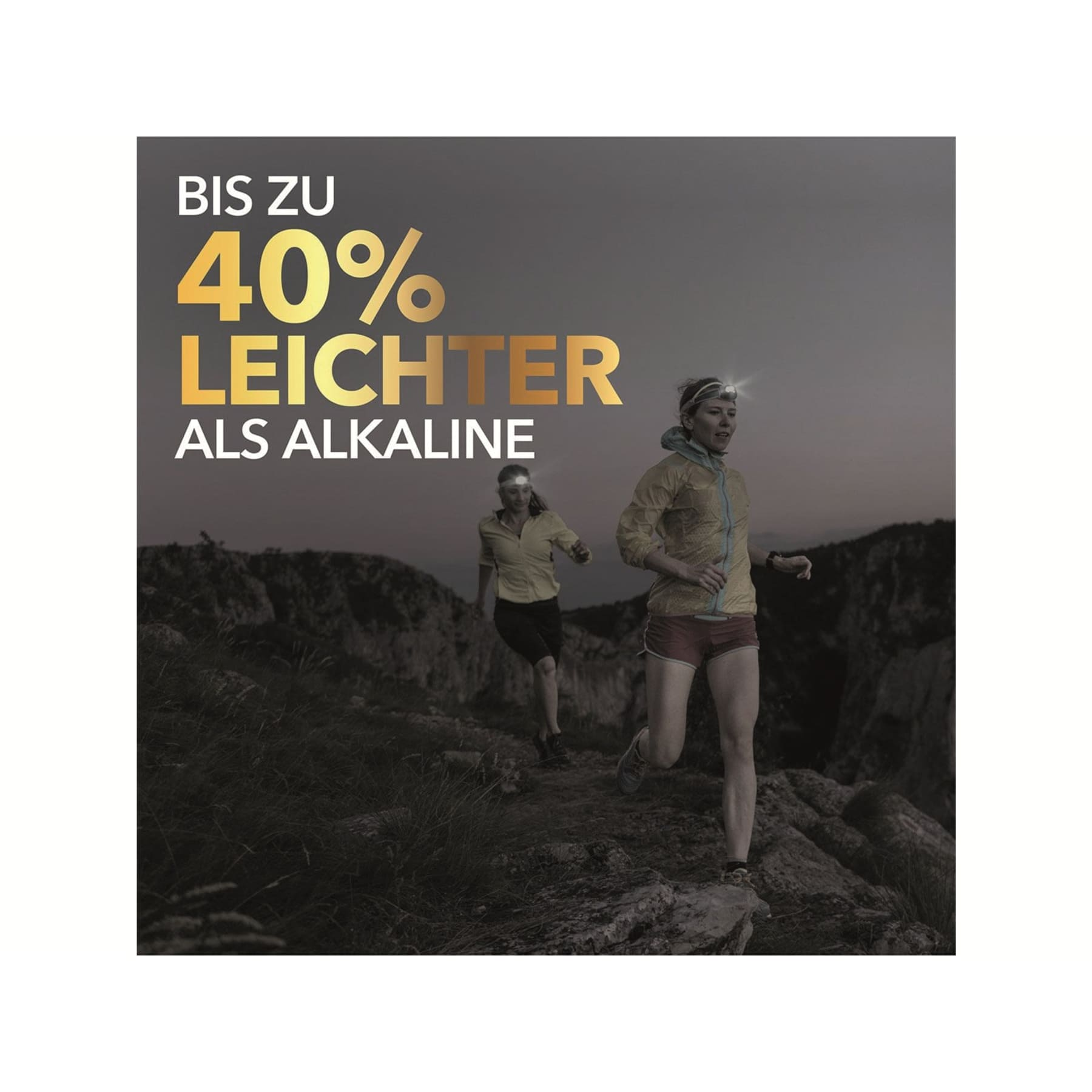 Dwóch biegaczy w lesie. Jeden ma lampę czołową. Tekst: 'Do 40% lżejsze'.