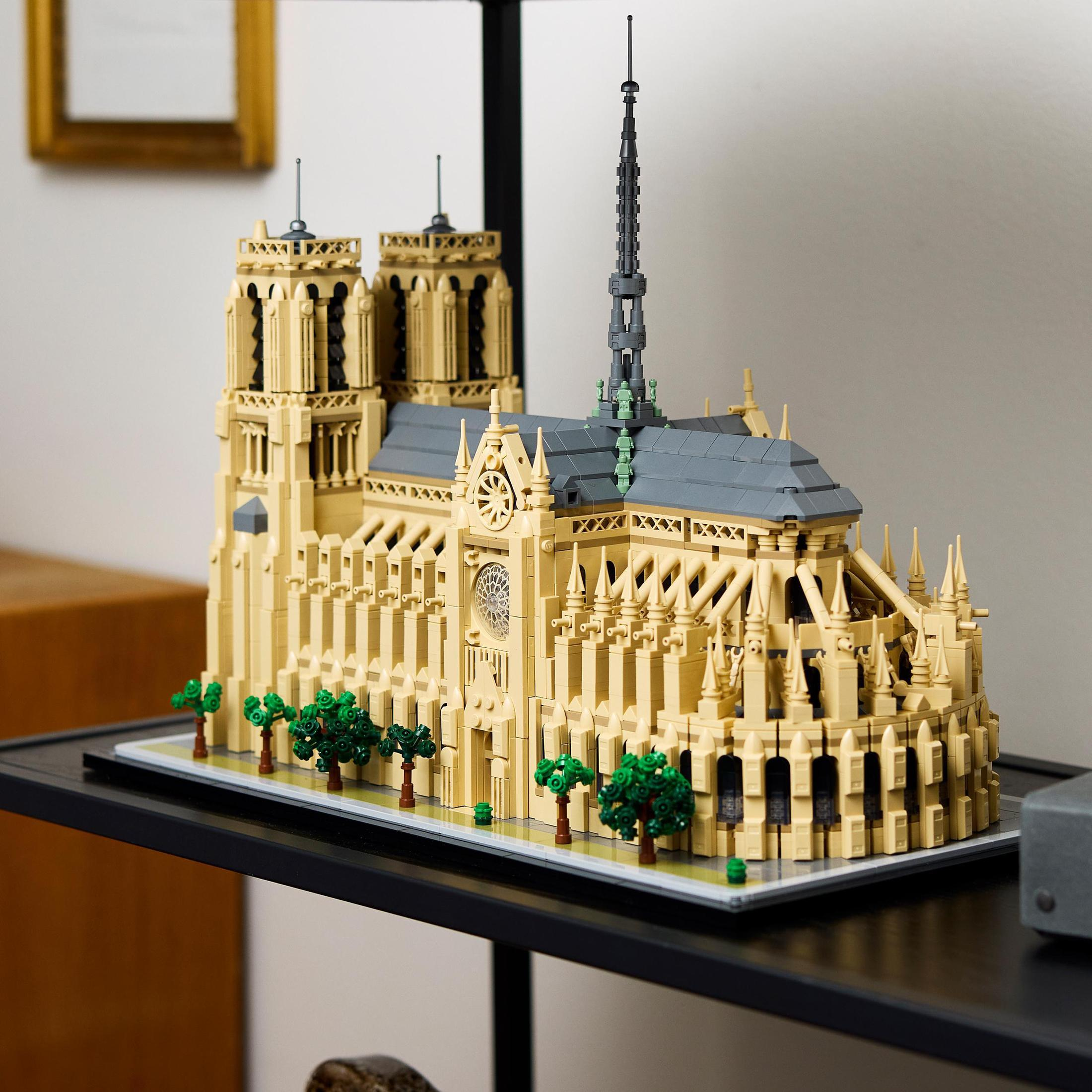 Model Lego Katedry Notre Dame na czarnej półce. Zielone drzewa wokół modelu.