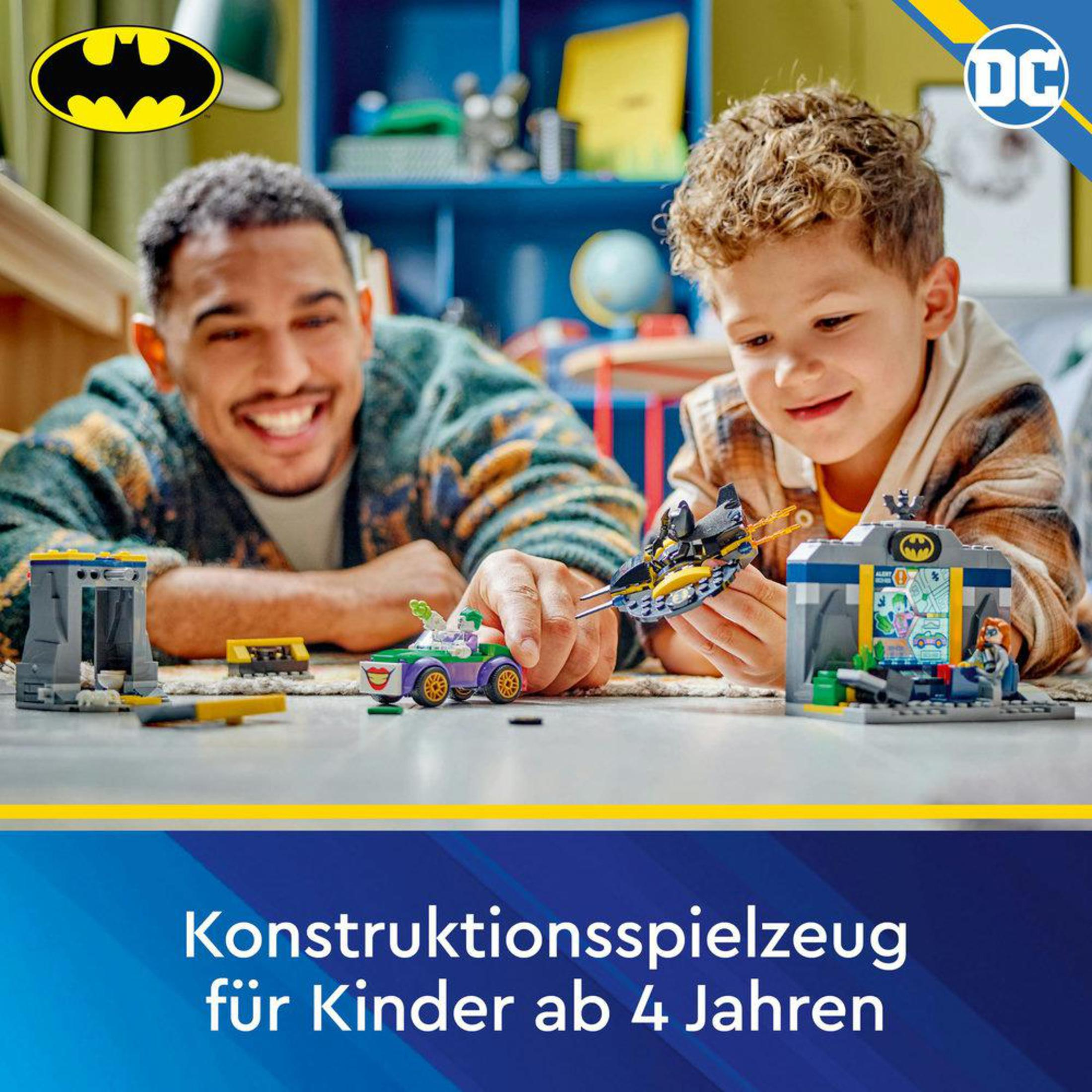 Ein Vater und Sohn spielen mit einem Lego Batman-Set. Der Junge lächelt und ist glücklich.