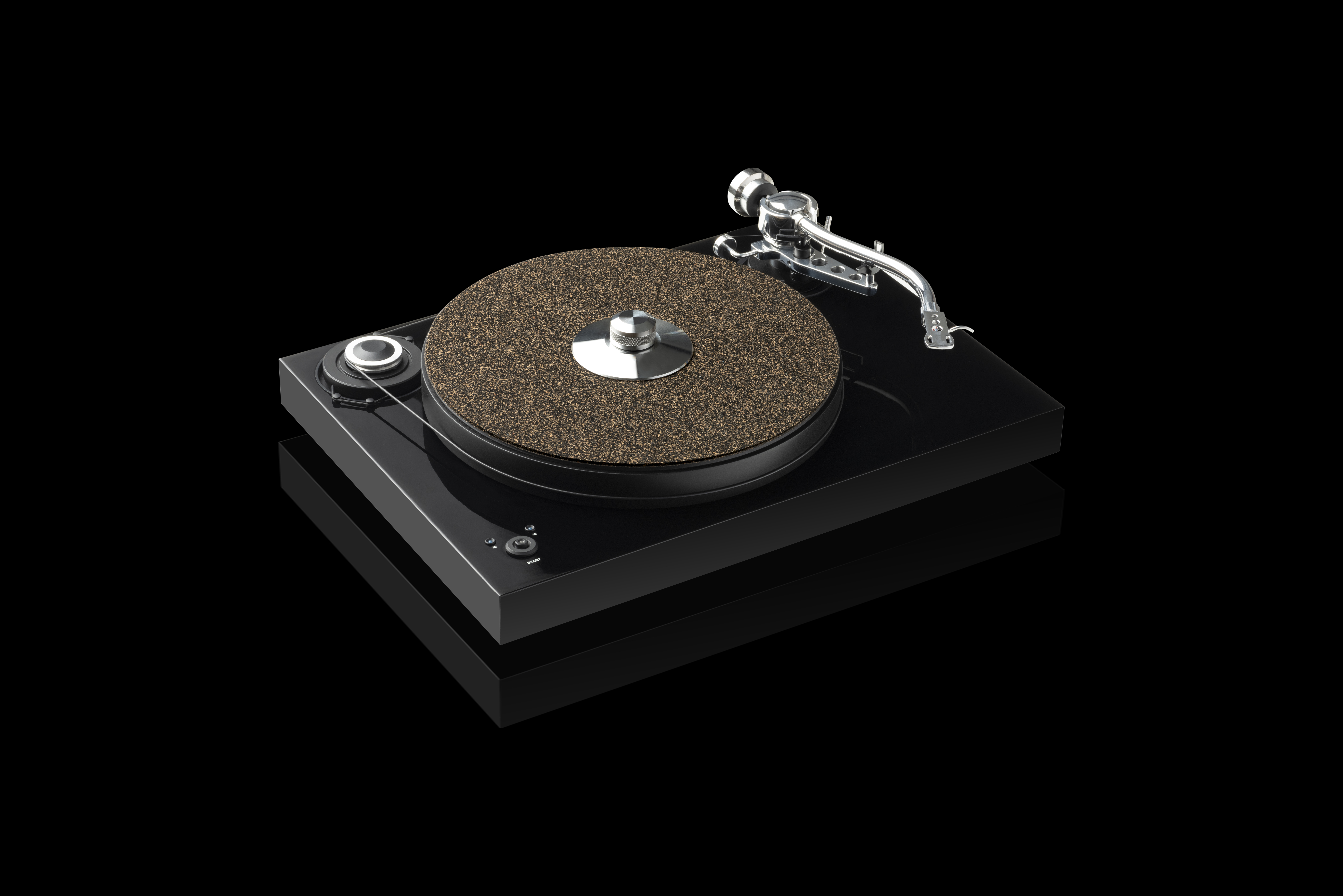A black record player on a black surface. The record player is on.