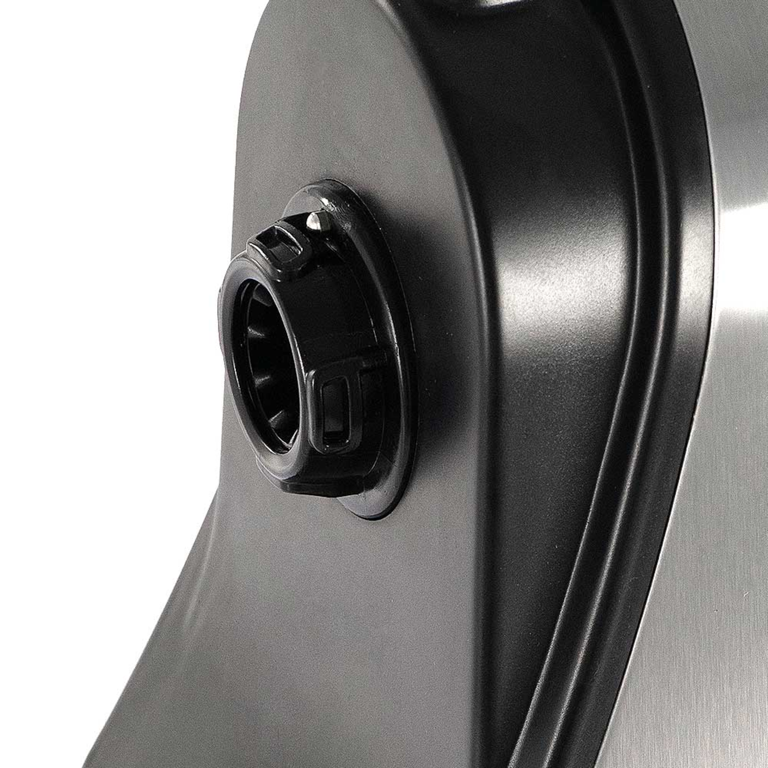 Nahaufnahme eines schwarzen Knopfes mit strukturierter Oberfläche auf Metall.
