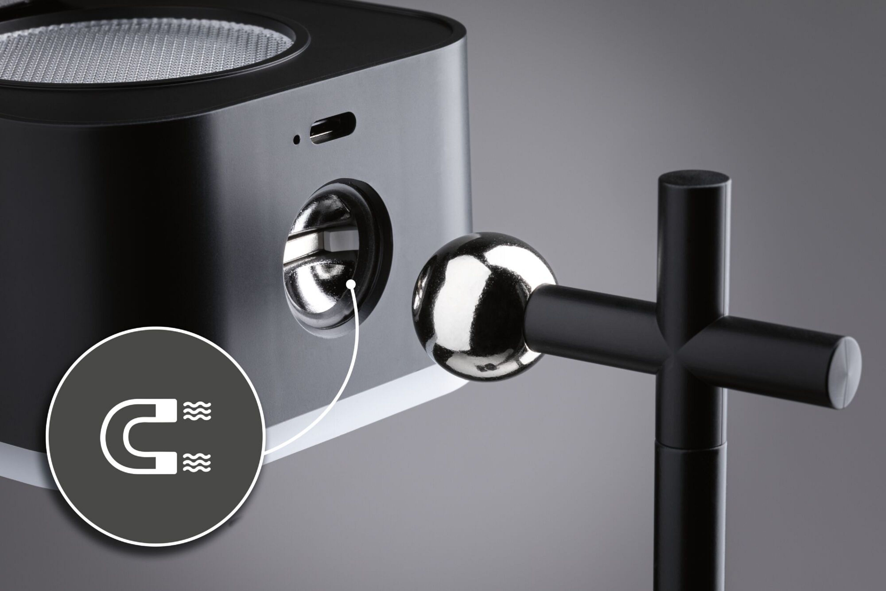 Czarne i srebrne urządzenie z mocowaniem magnetycznym. Dołączona jest metalowa kula.