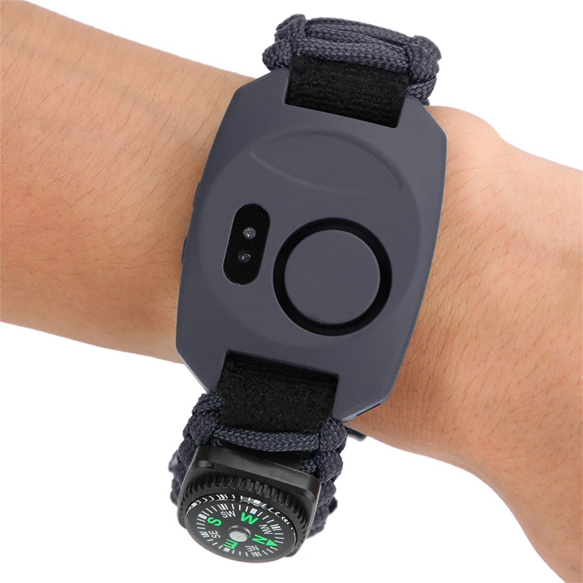 Ein Armband mit Kompass und schwarzem Band. Es befindet sich am Handgelenk einer Person.