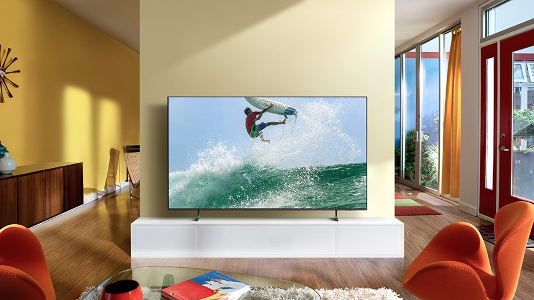 Un televisor muestra a un surfista en una ola en una habitación con decoración moderna.
