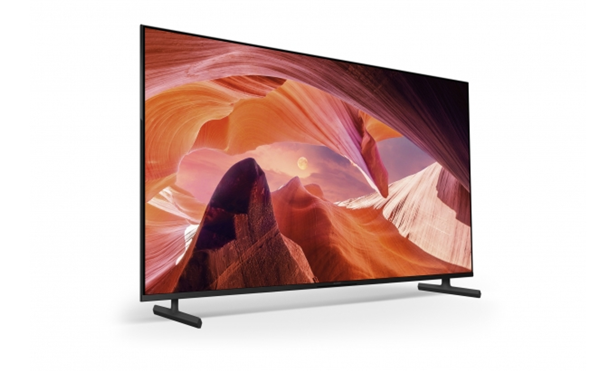 Una TV mostra una scena del canyon. Ha una cornice e un supporto neri su sfondo bianco.