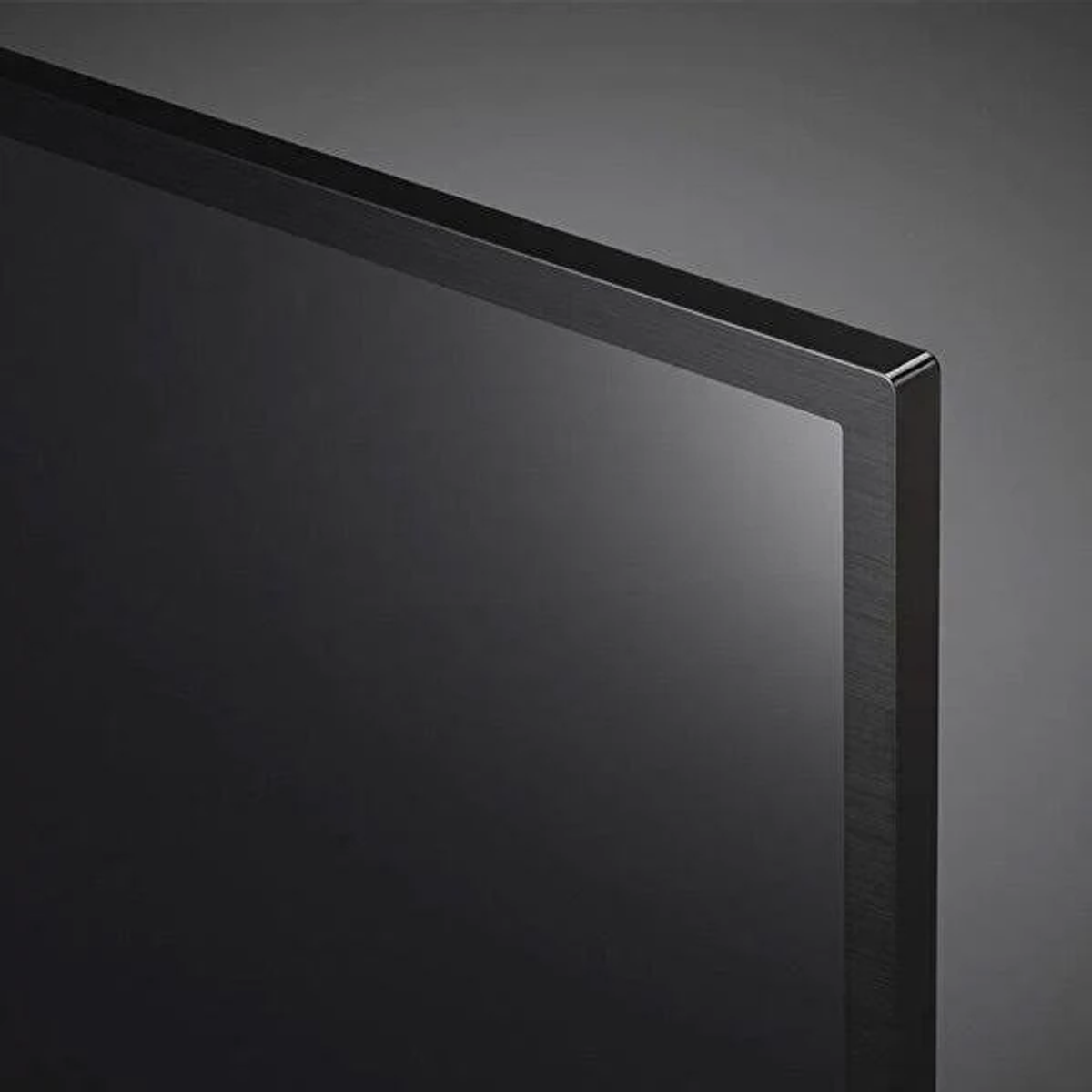 Angolo dello schermo TV nero, primo piano, con cornice nera, su sfondo scuro.