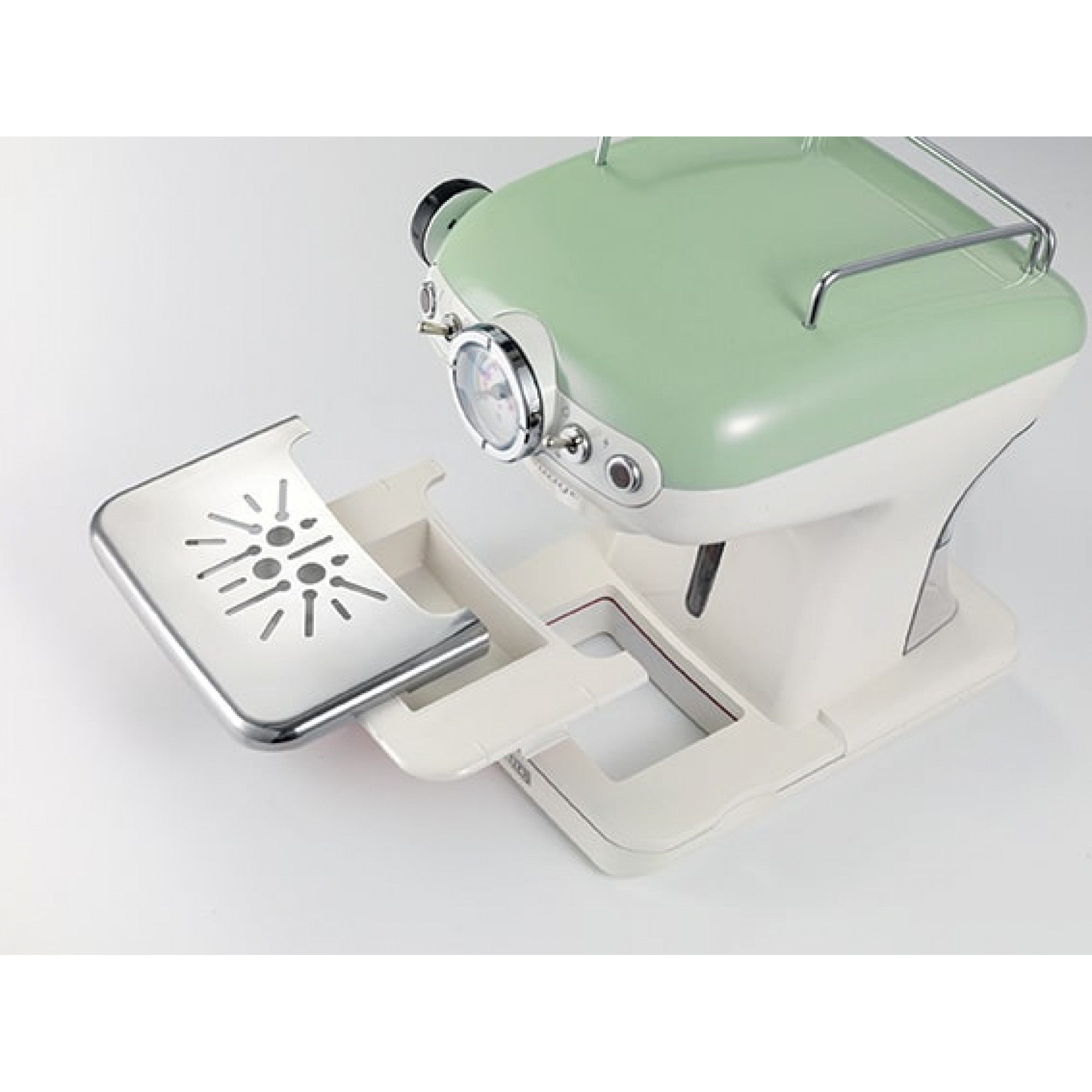 Kaffeemaschine im Retro-Stil in Grün und Weiß mit ausgezogenem Tablett. Sie steht auf einer weißen Oberfläche.
