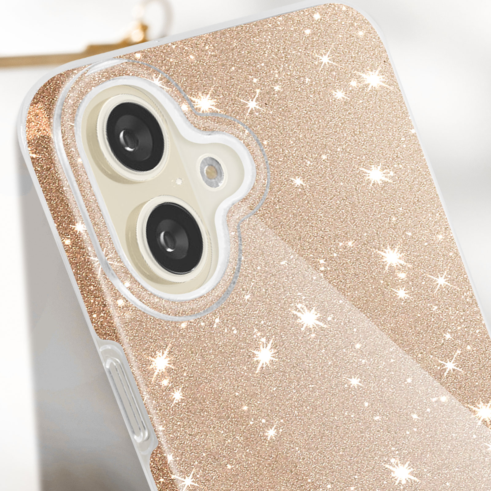Nahaufnahme einer Handyhülle mit glitzernder Goldoberfläche und sternförmigen Glitzerpartikeln.