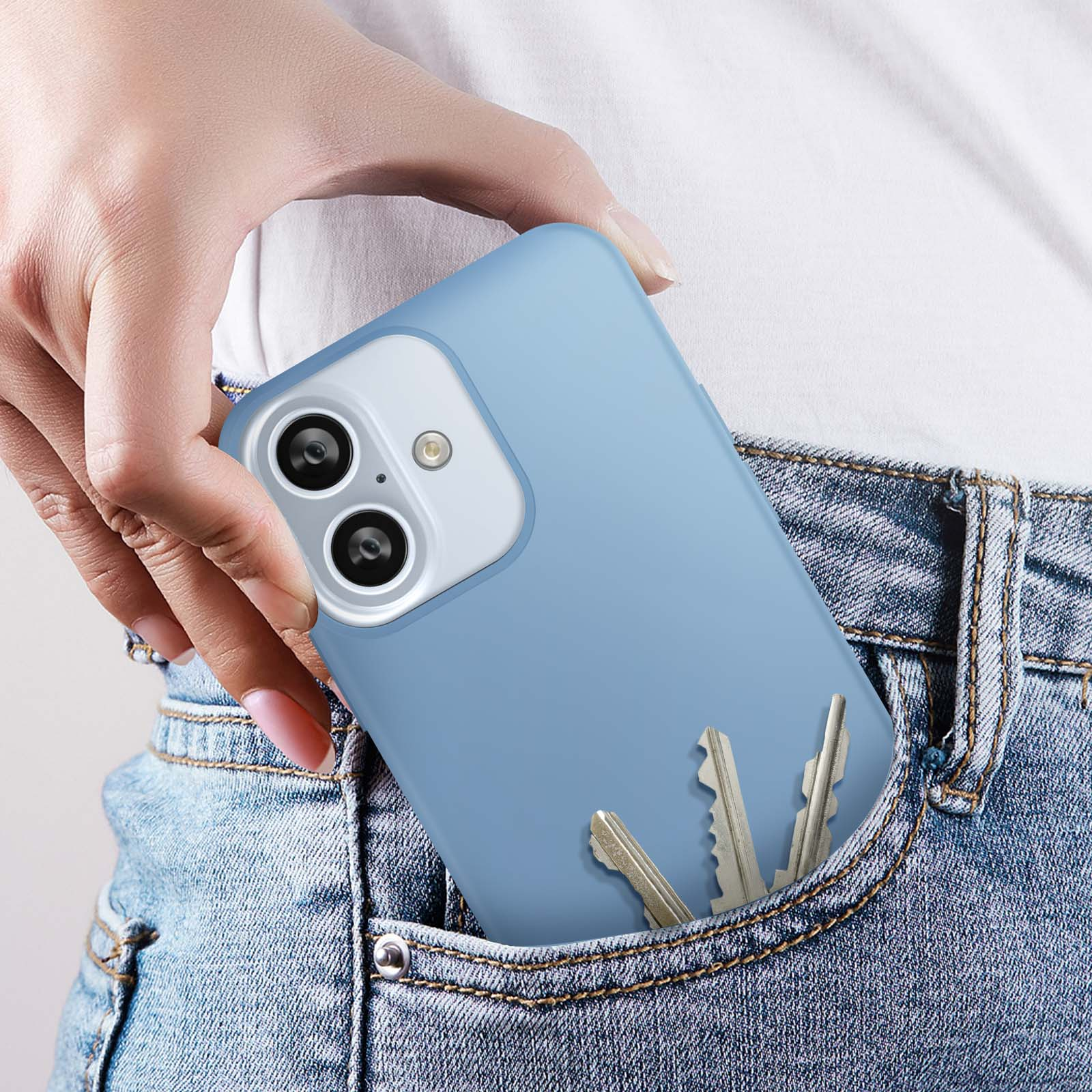 Una donna che tira fuori un telefono blu da una tasca dei jeans. Le chiavi sono anche in tasca.