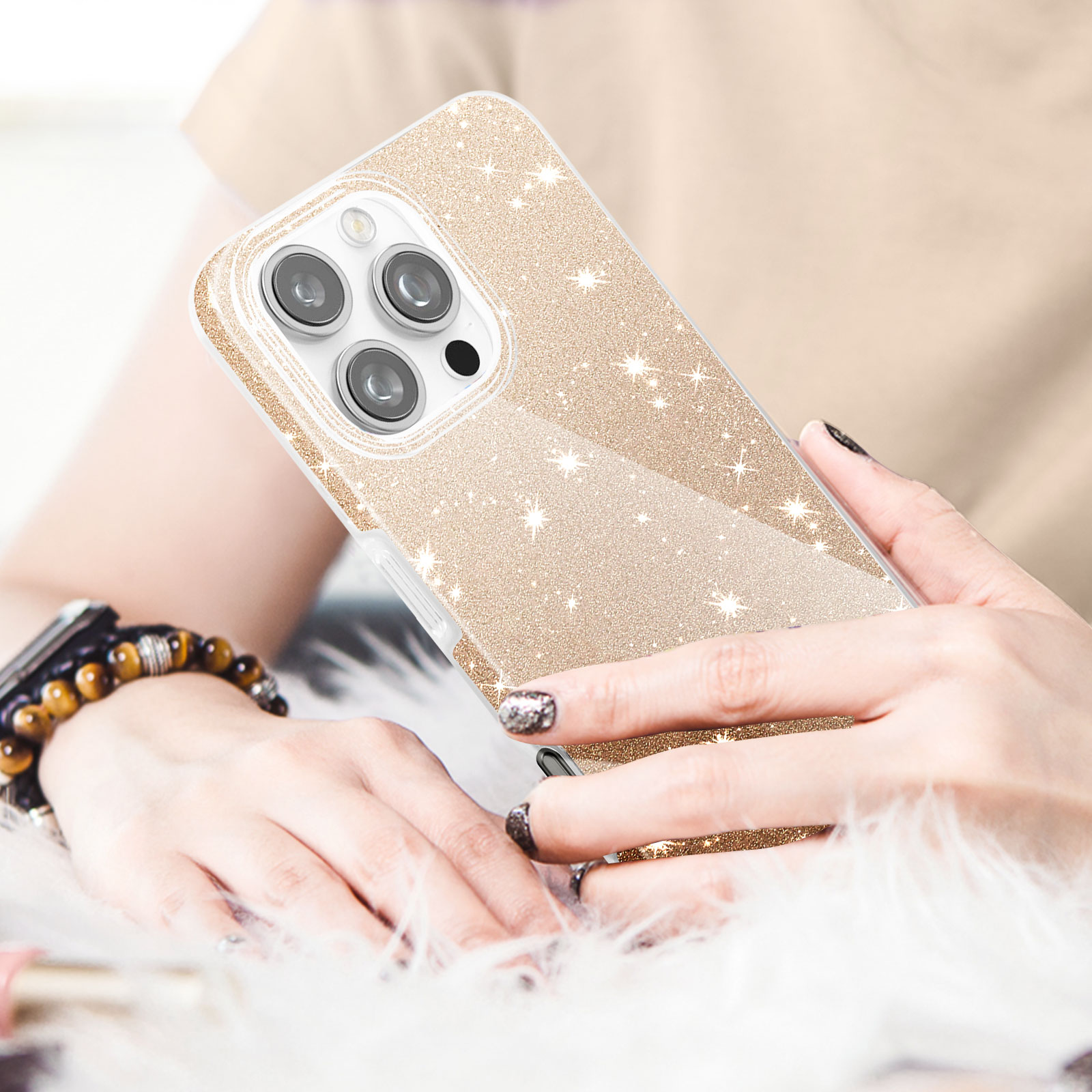 Eine Hand, die eine glitzernde goldene Handyhülle mit einem Telefon darin auf einer flauschigen weißen Oberfläche hält.