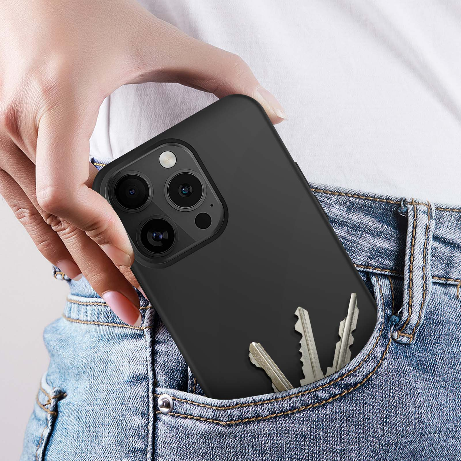 La mano di una persona che tiene un telefono con custodia nera e chiavi in tasca.