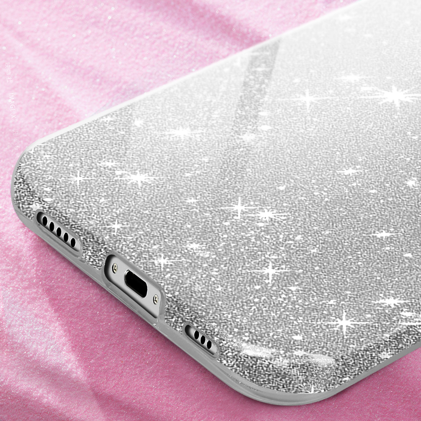 Primo piano di una cover argentata glitterata su una superficie rosa.