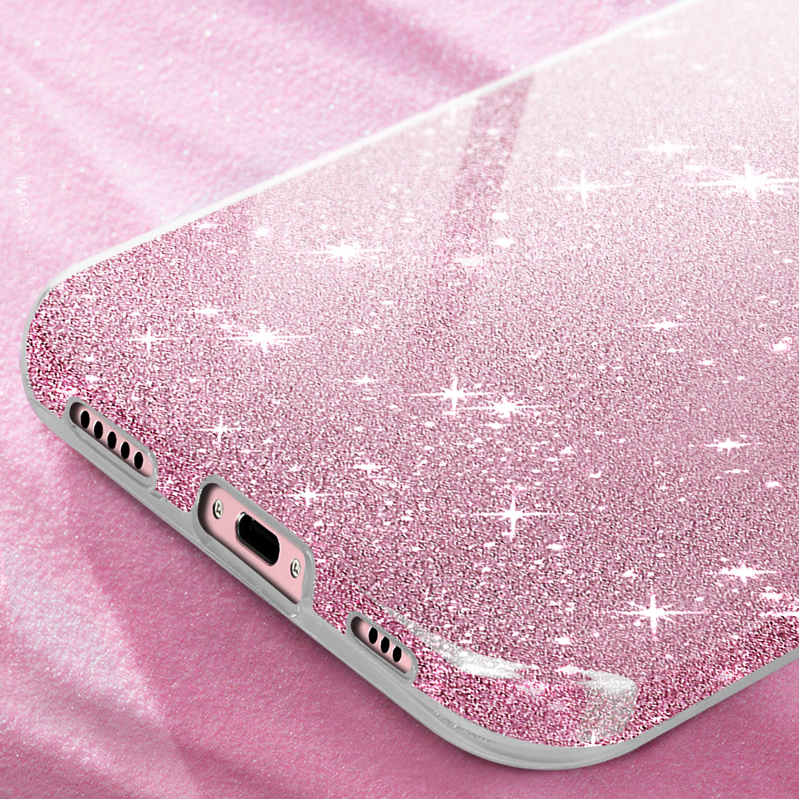 Un primo piano di una cover per telefono rosa glitterata, che mostra l'angolo con la fotocamera e le porte di ricarica.