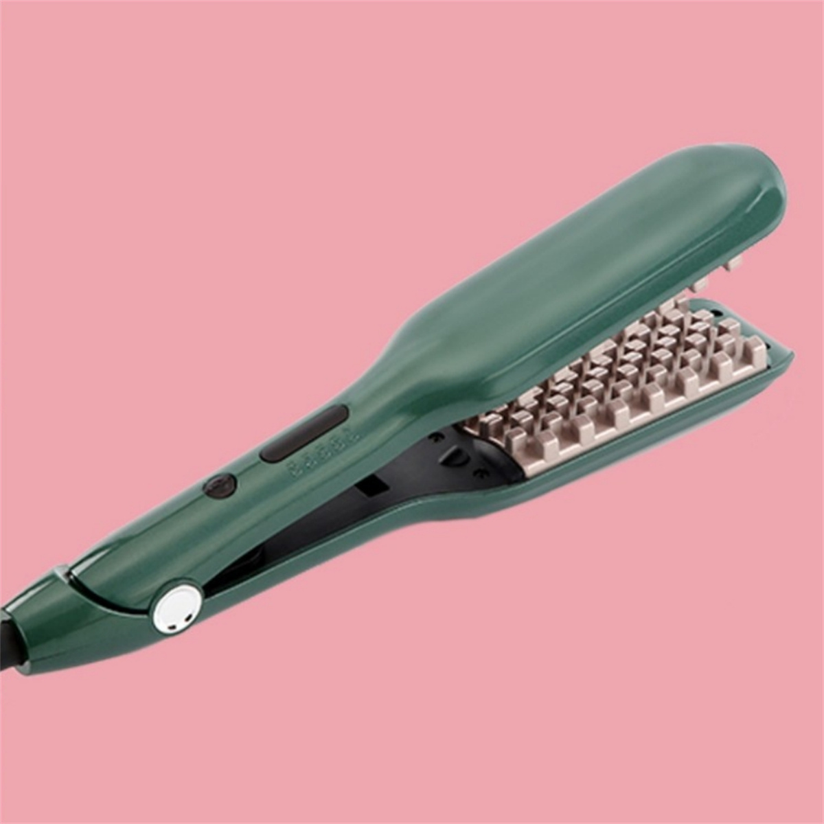 Grüner Haarglätter auf rosa Hintergrund.