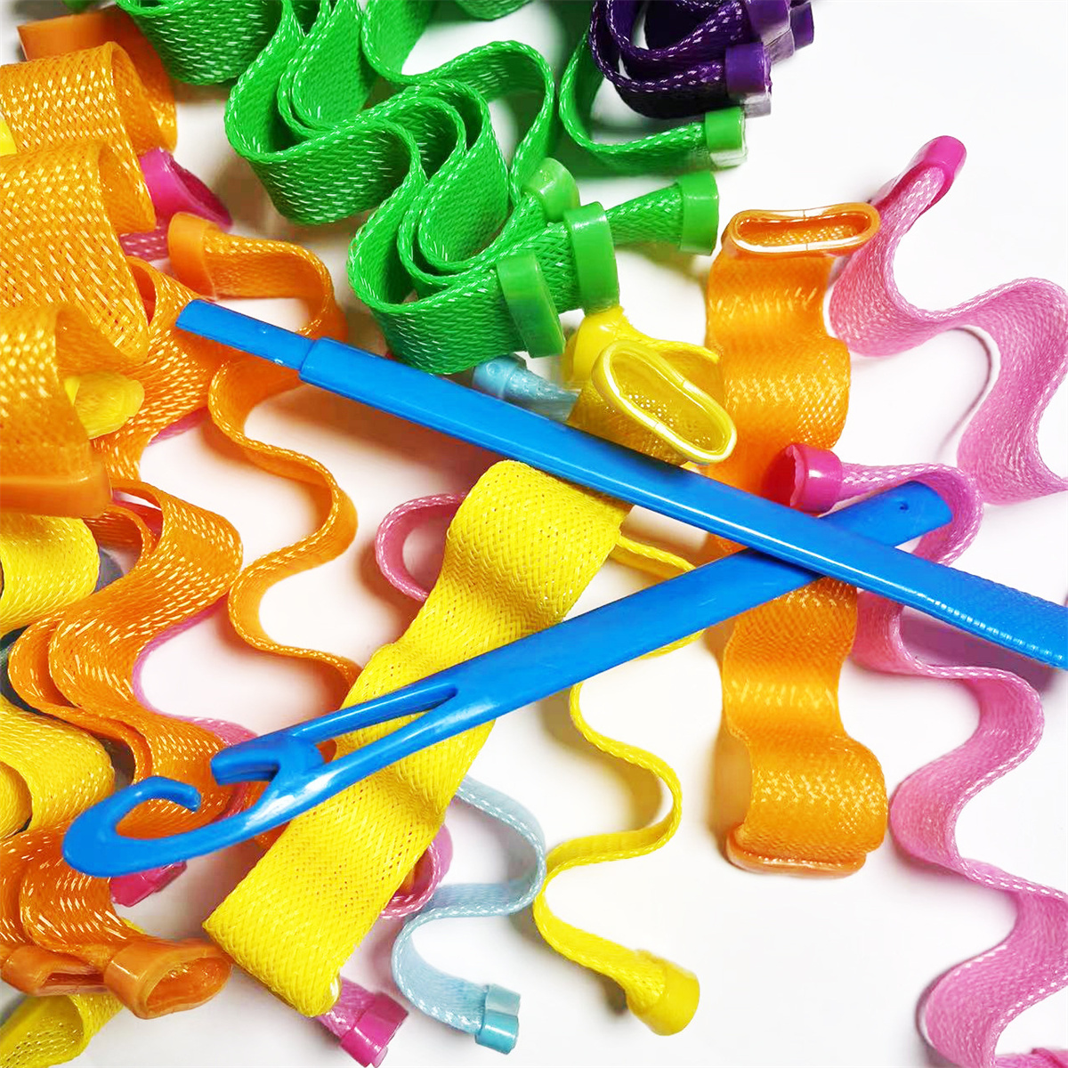Bunte Haarwickler in verschiedenen Formen und Farben, darunter Orange, Grün, Gelb, Rosa und Blau.