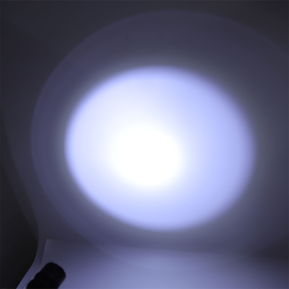 Ein helles, weißes Licht scheint in einem dunklen Raum und erzeugt einen kreisförmigen Spotlichteffekt.