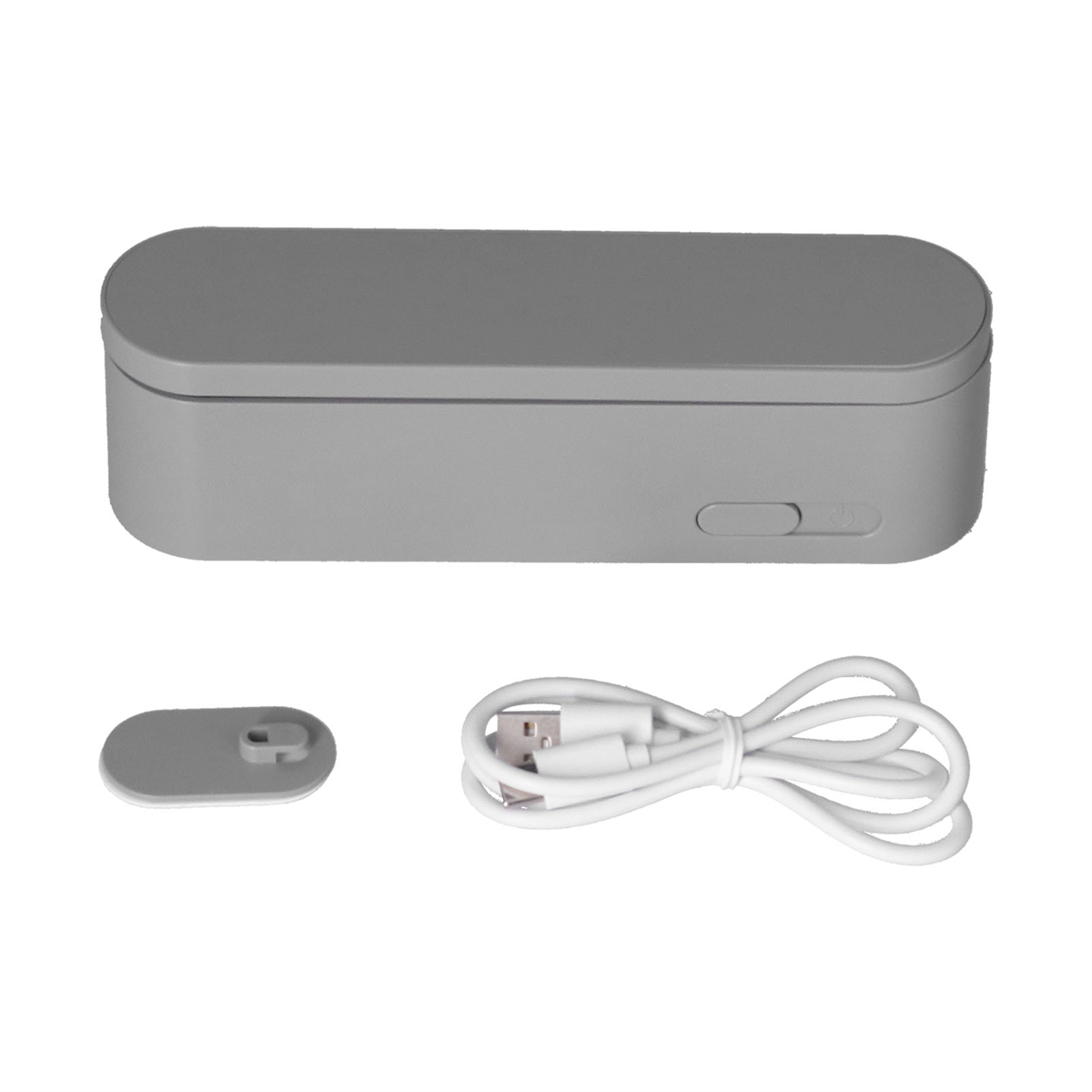 Graue, rechteckige Desinfektionsbox mit offenem Deckel, einem kleinen Tablett und einem USB-Kabel.