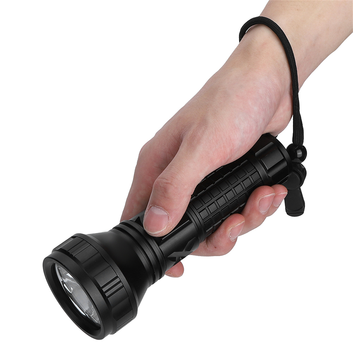 Eine Person hält eine schwarze Taschenlampe mit schwarzem Riemen. Das Licht ist an.