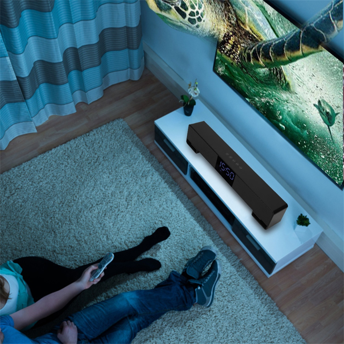 Eine schwarze Soundbar auf einem weißen Regal, mit einem Fernsehbildschirm, der eine Schildkröte zeigt.