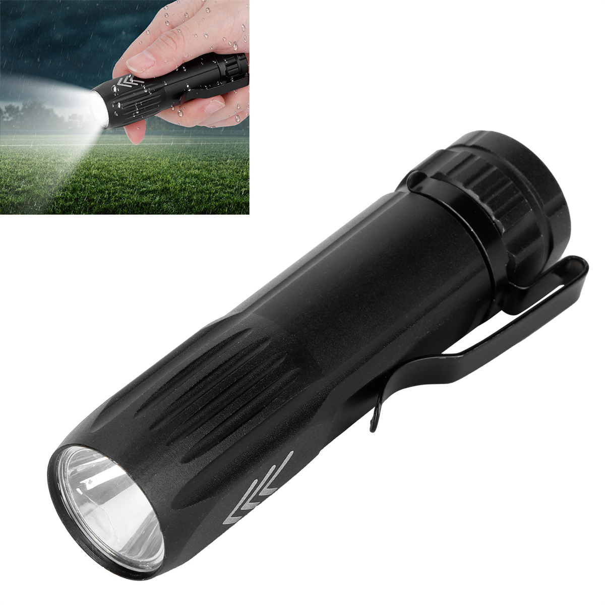 Schwarze Taschenlampe, die Licht scheint. Hand hält sie im Regen vor einem grünen Feld.