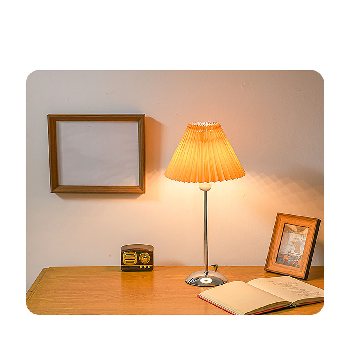 Tischlampe mit plissiertem Schirm. Holzrahmen und Radio auf einem Holztisch.