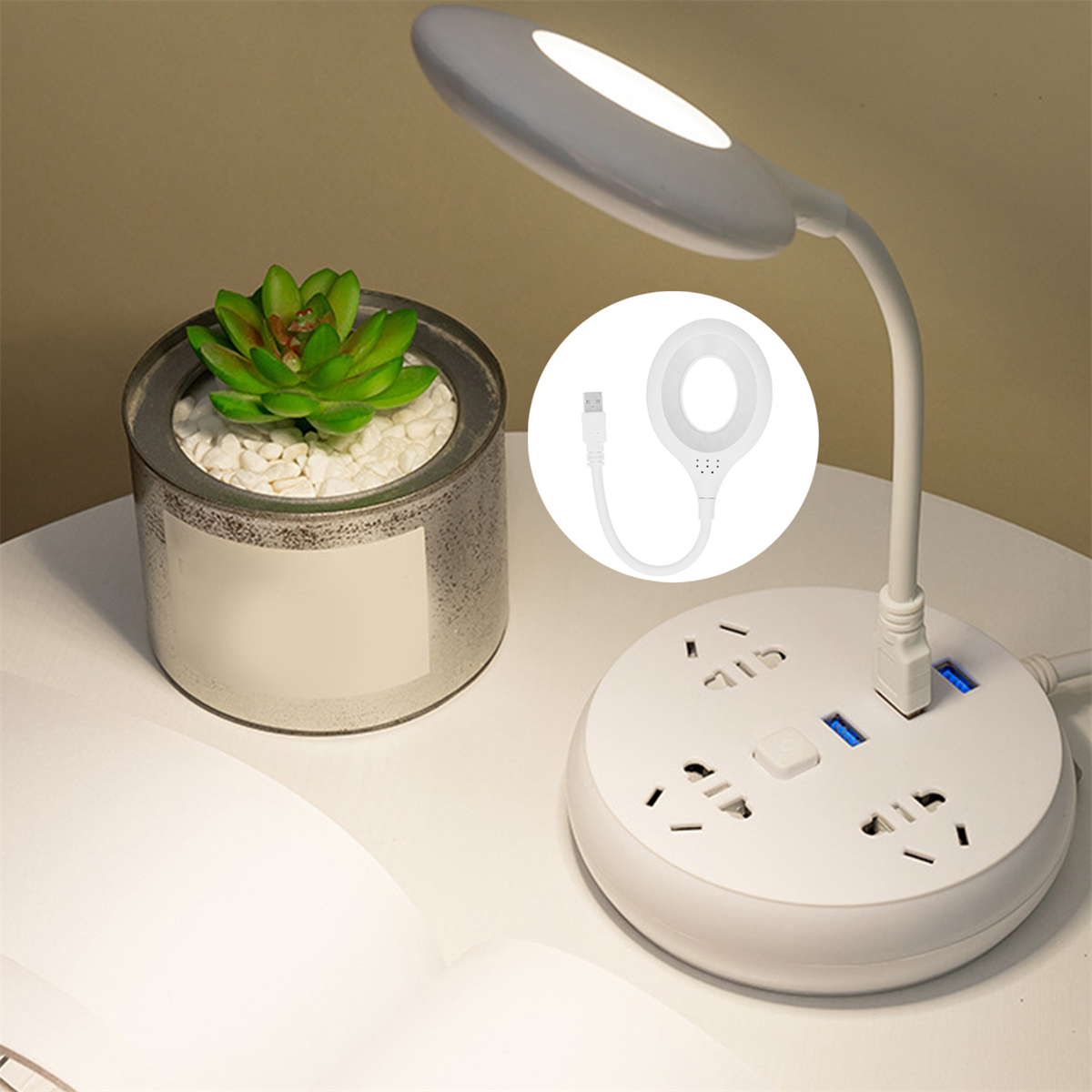 Weiße Schreibtischlampe mit flexiblem Hals, eine kleine Topfpflanze und eine weiße Steckdosenleiste mit USB-Anschlüssen.