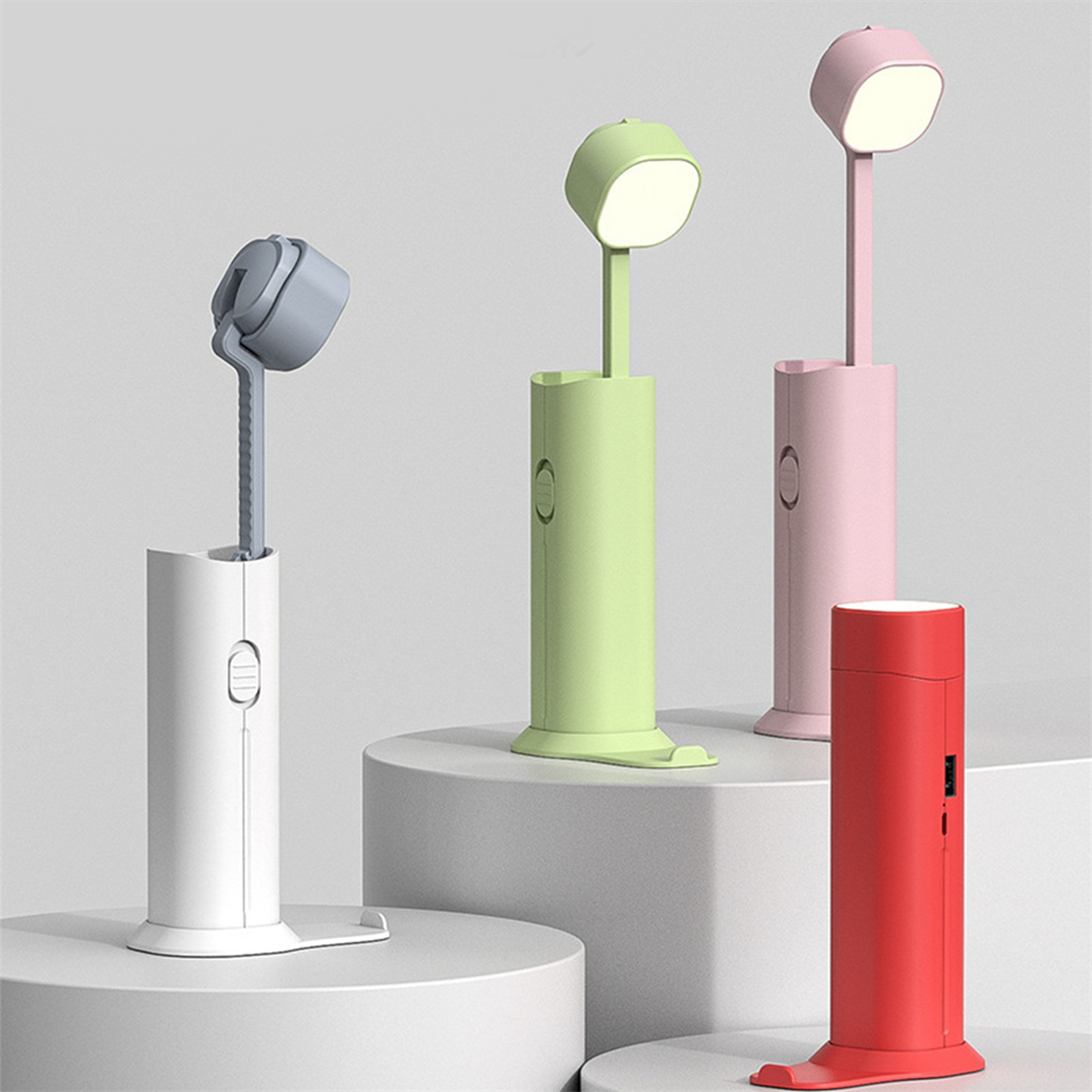 Vier bunte Schreibtischlampen. Jede Lampe hat eine einzigartige Farbe. Die Lampen stehen in einer Reihe. Jede Lampe hat eine andere Form.