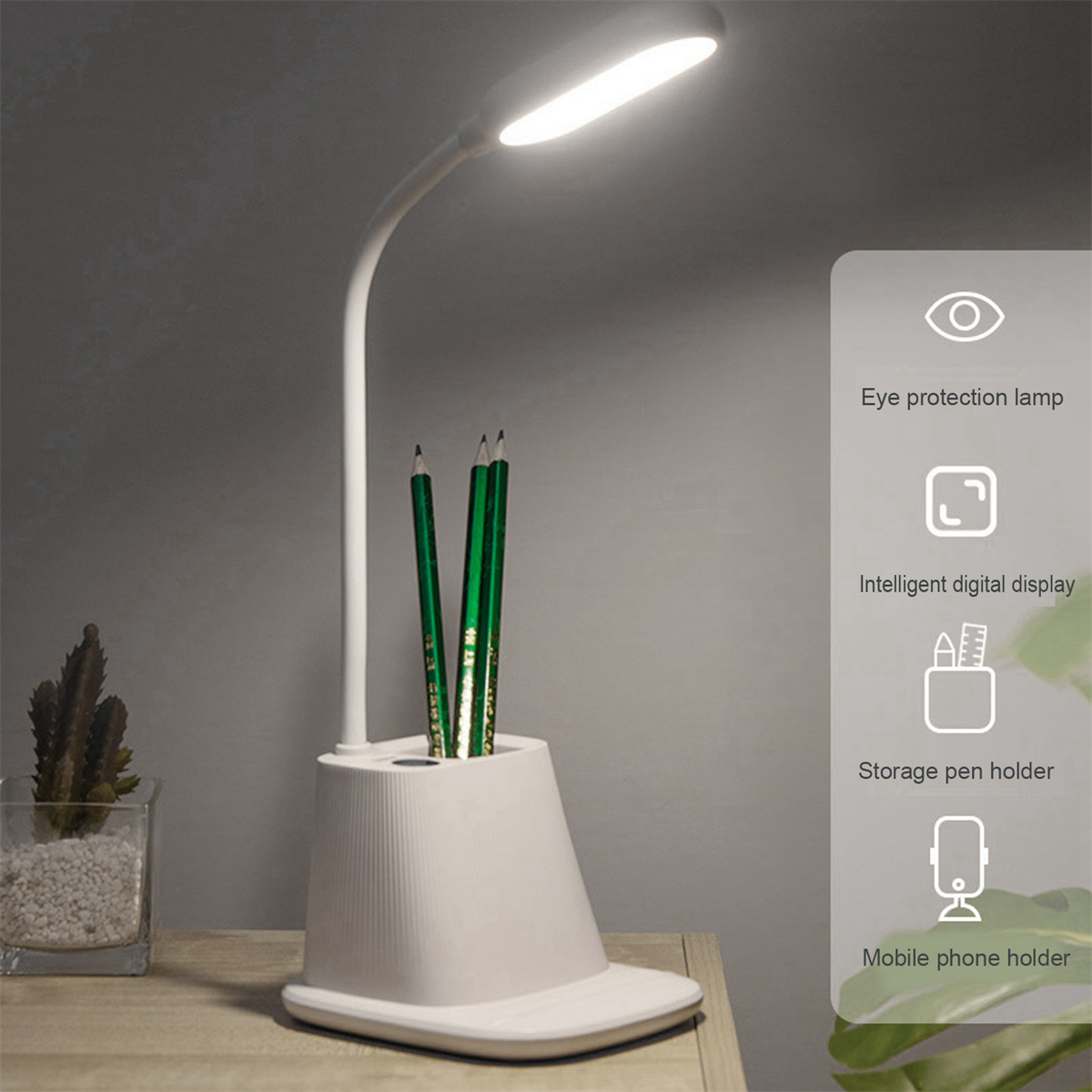 Weiße Schreibtischlampe mit gebogenem Hals. Drei grüne Bleistifte in einem weißen Stifthalter.