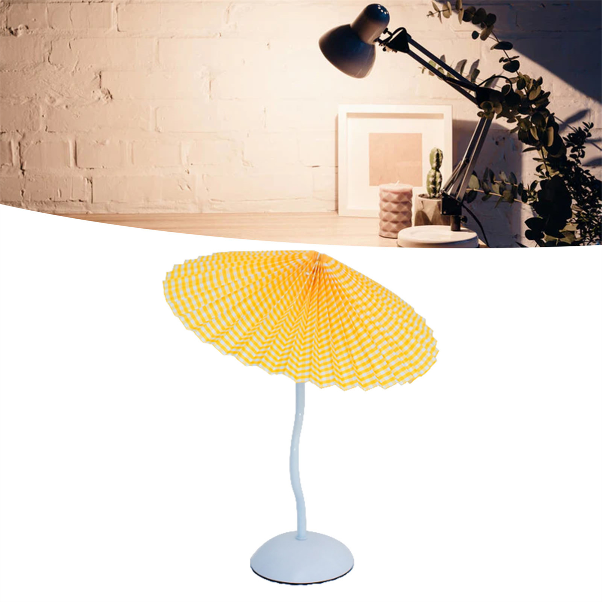 Ein gelb-weißer Papierregenschirm mit Lampe und Tisch.