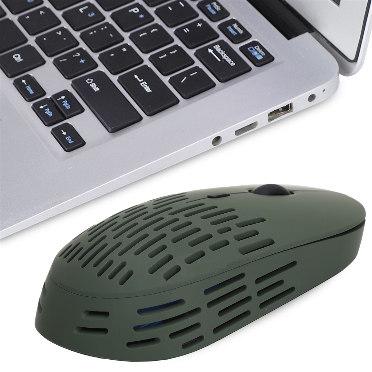 Grüne Maus neben einem Laptop. Maus hat Lüftungsschlitze. Weißer Hintergrund.