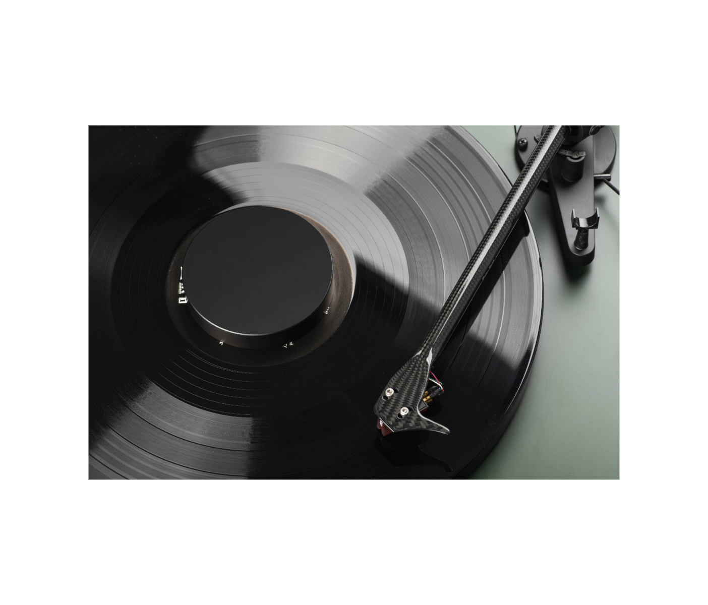 Een platenspeler met een zwarte vinylplaat. De toonarm staat op zijn plaats en de plaat draait.